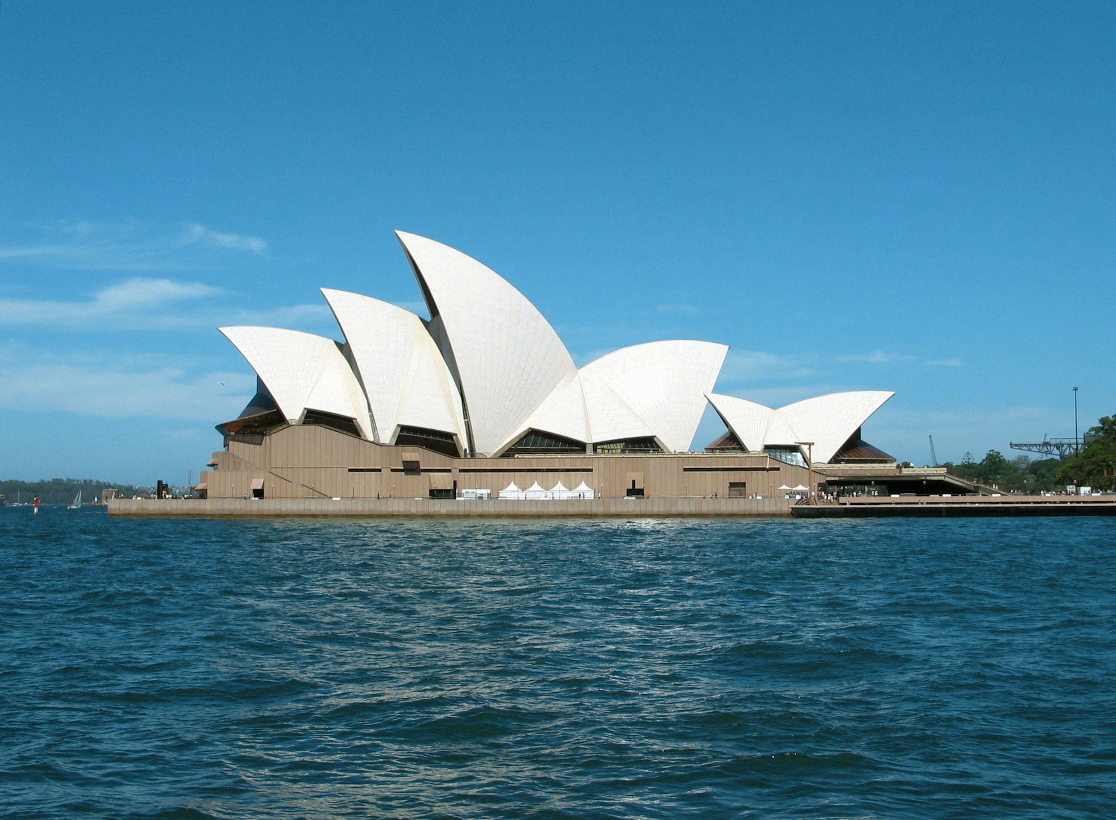 Sydney Opera House con techos blancos en forma de vela contra un cielo azul