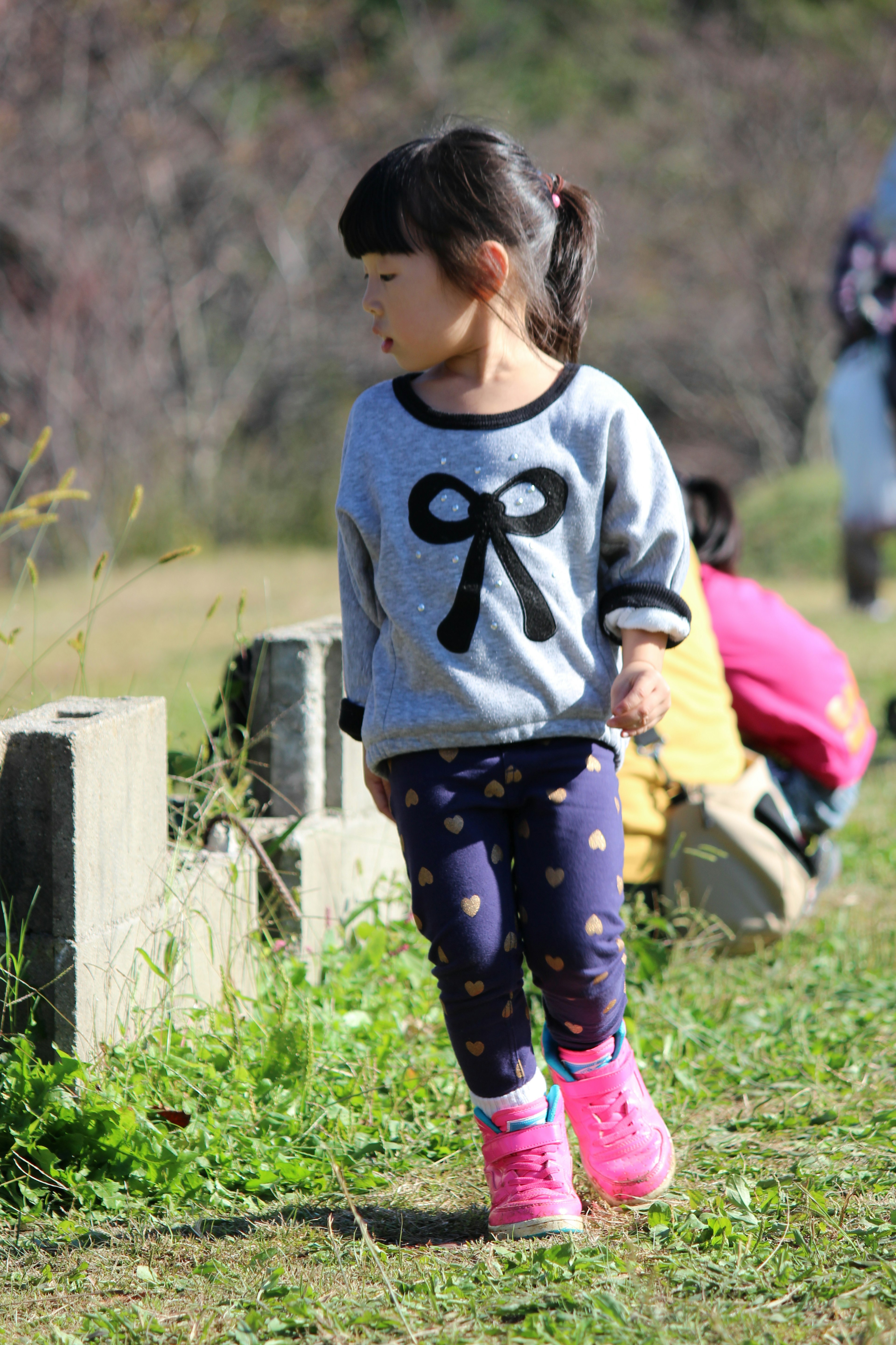 Girl wearing a bow design sweater walking outdoors