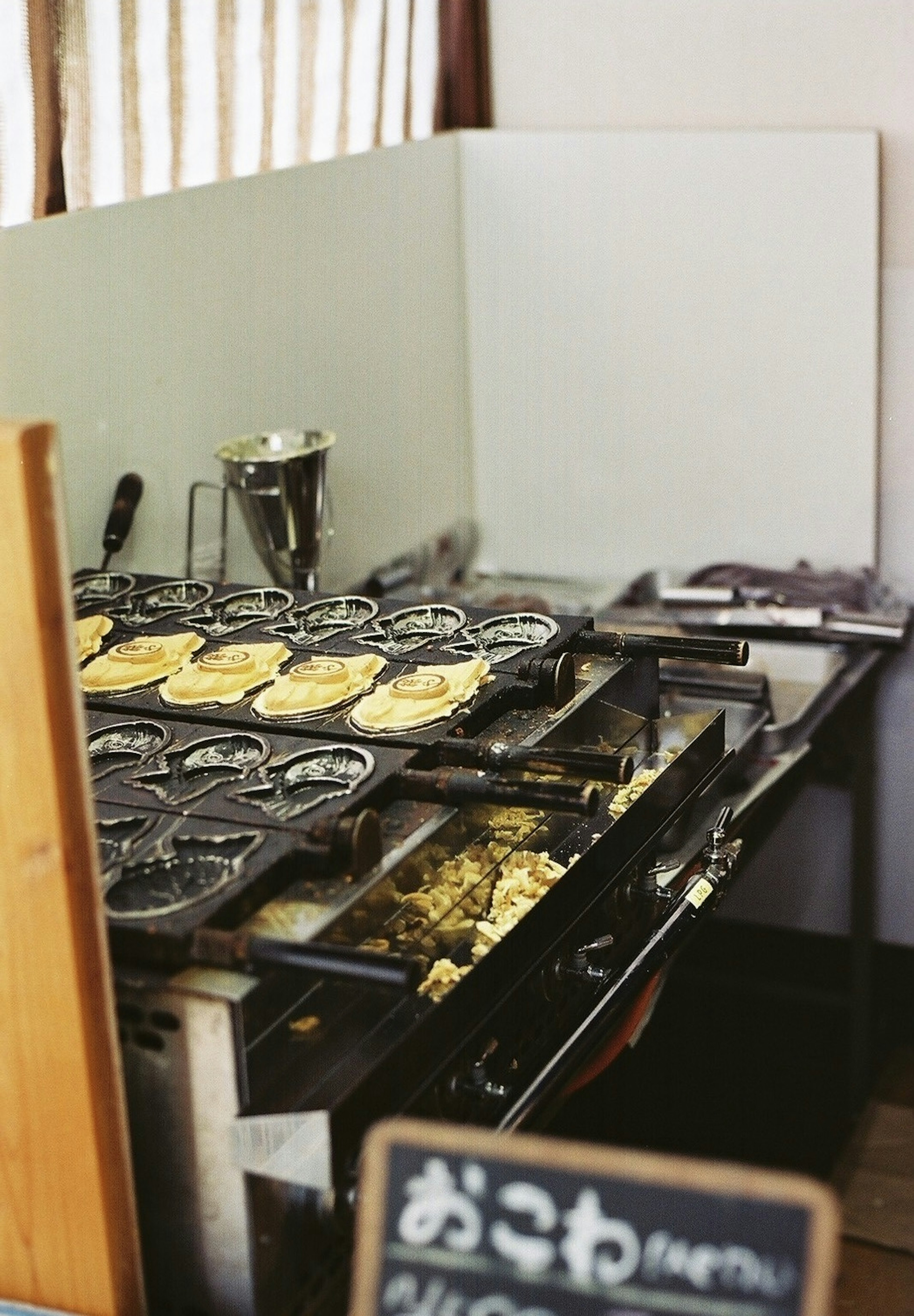 Estación de cocina de okonomiyaki con okonomiyaki a la parrilla e ingredientes