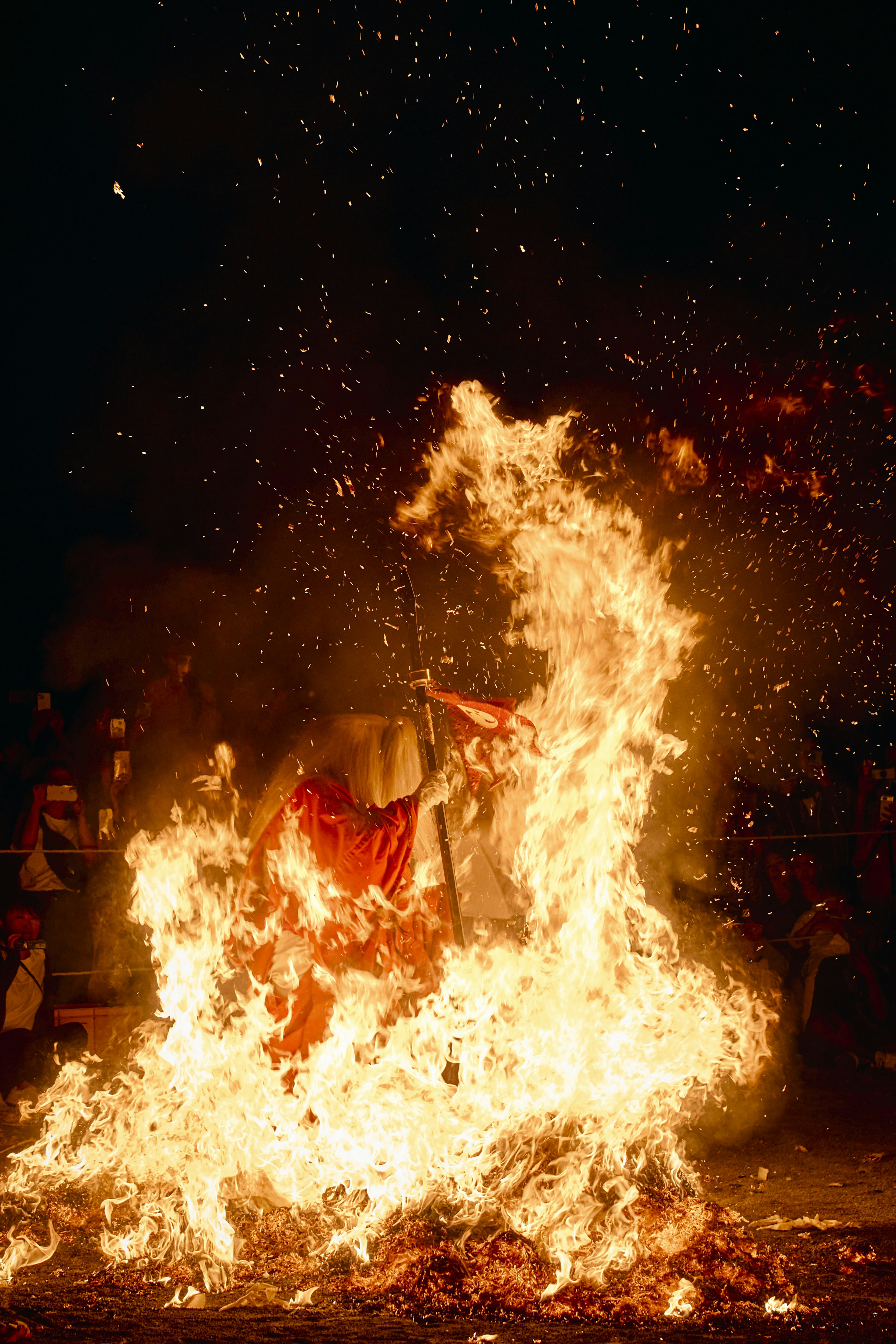 Person dancing in flames with spectators in the background