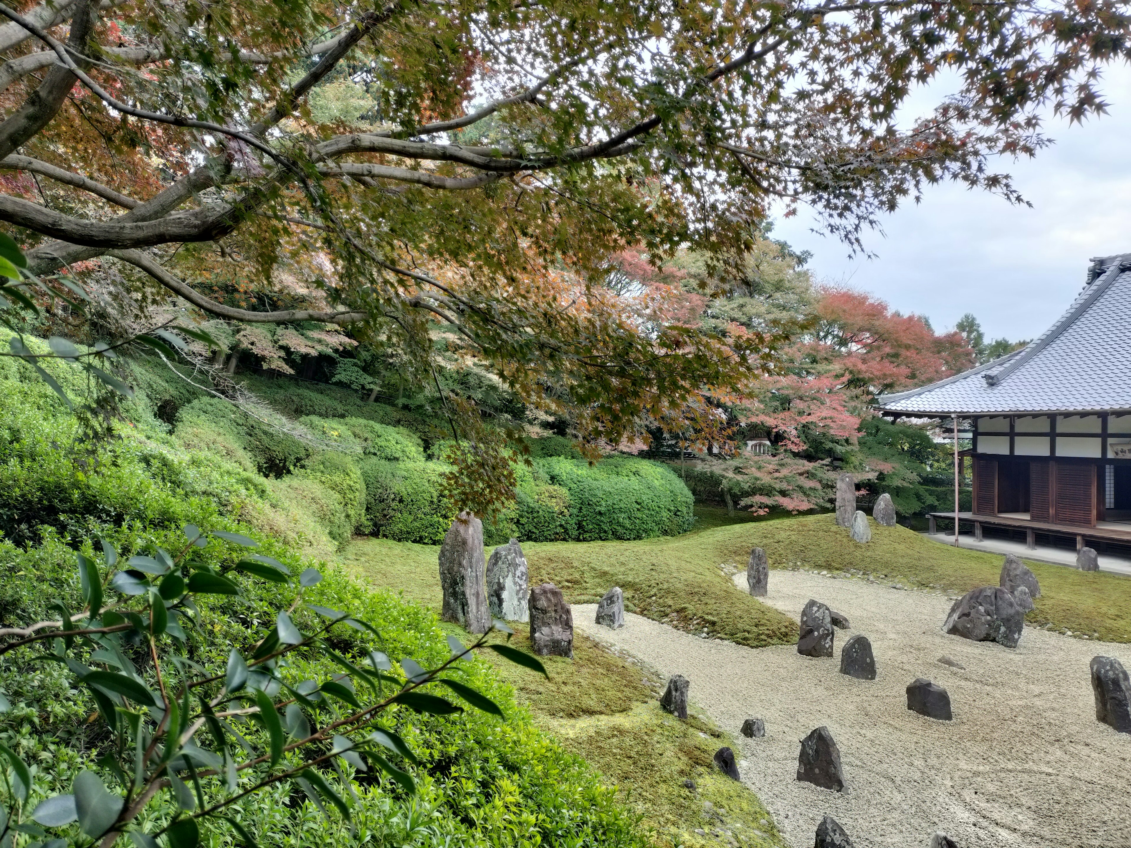 Vue panoramique d'un jardin japonais avec des pierres sereines et une verdure luxuriante