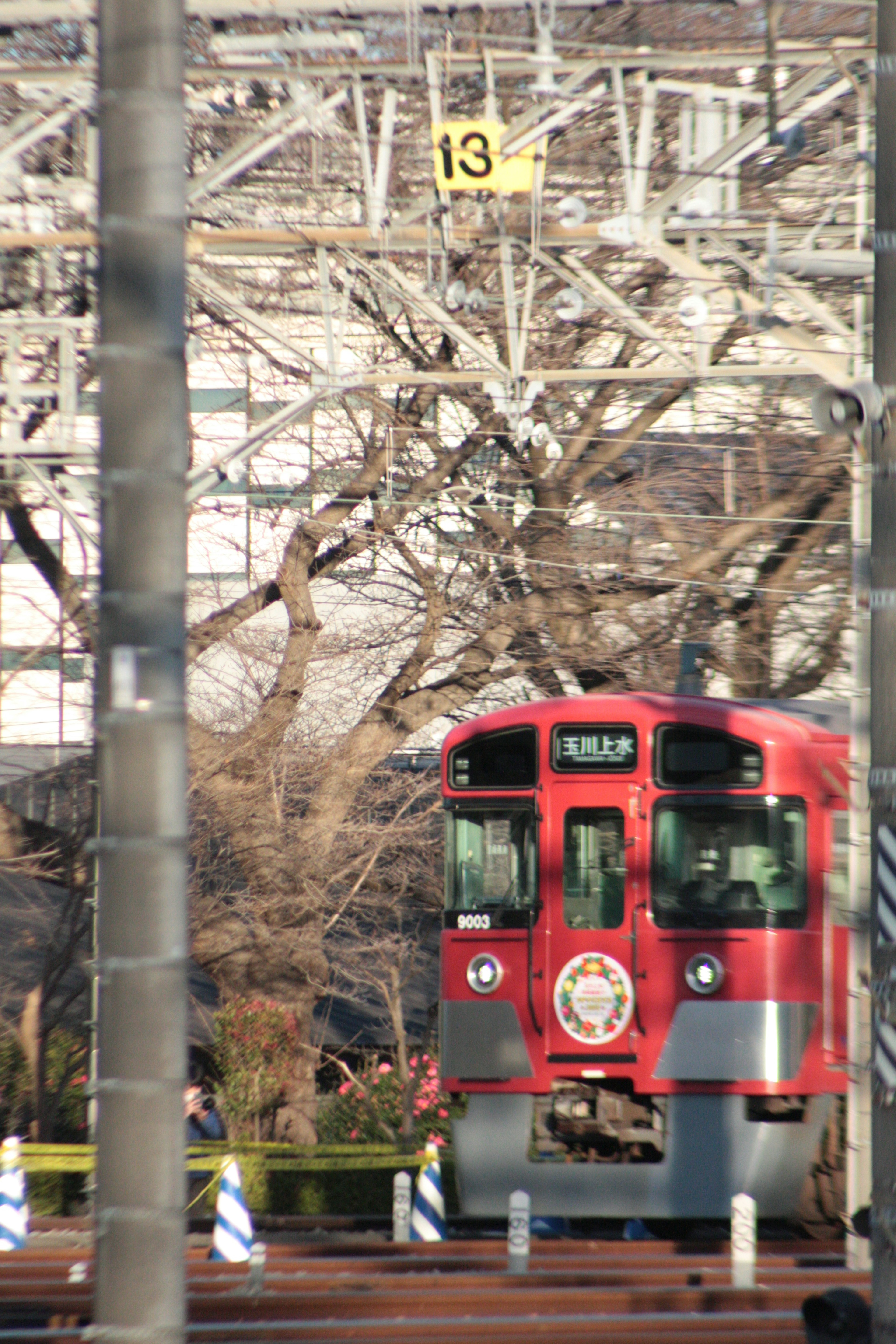 Red train in a railway setting with sign number 134 and trees in the background