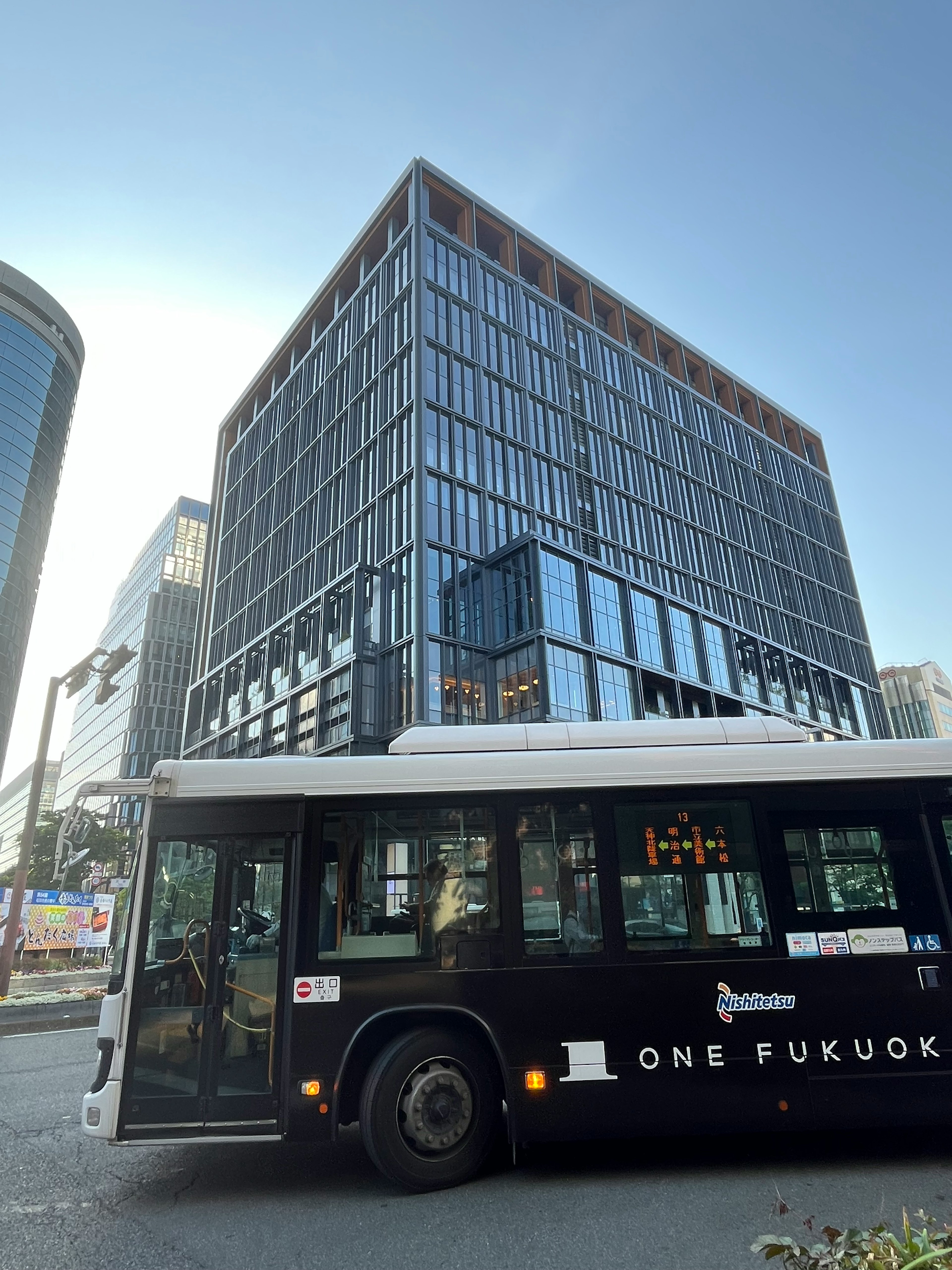 黒いバスとガラスのビルが写っている都市の風景