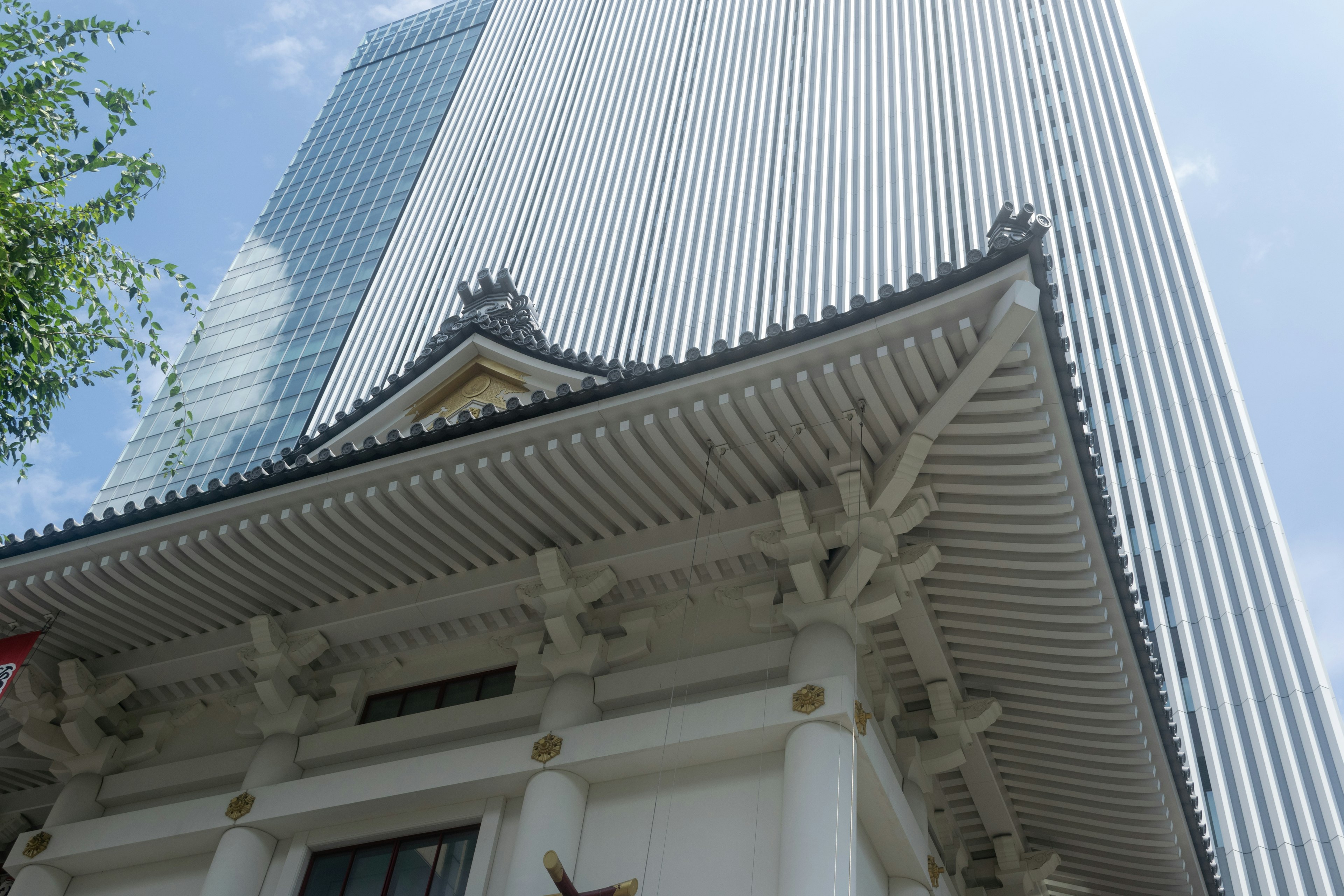 Foto yang menunjukkan kontras antara gedung pencakar langit dan bangunan tradisional