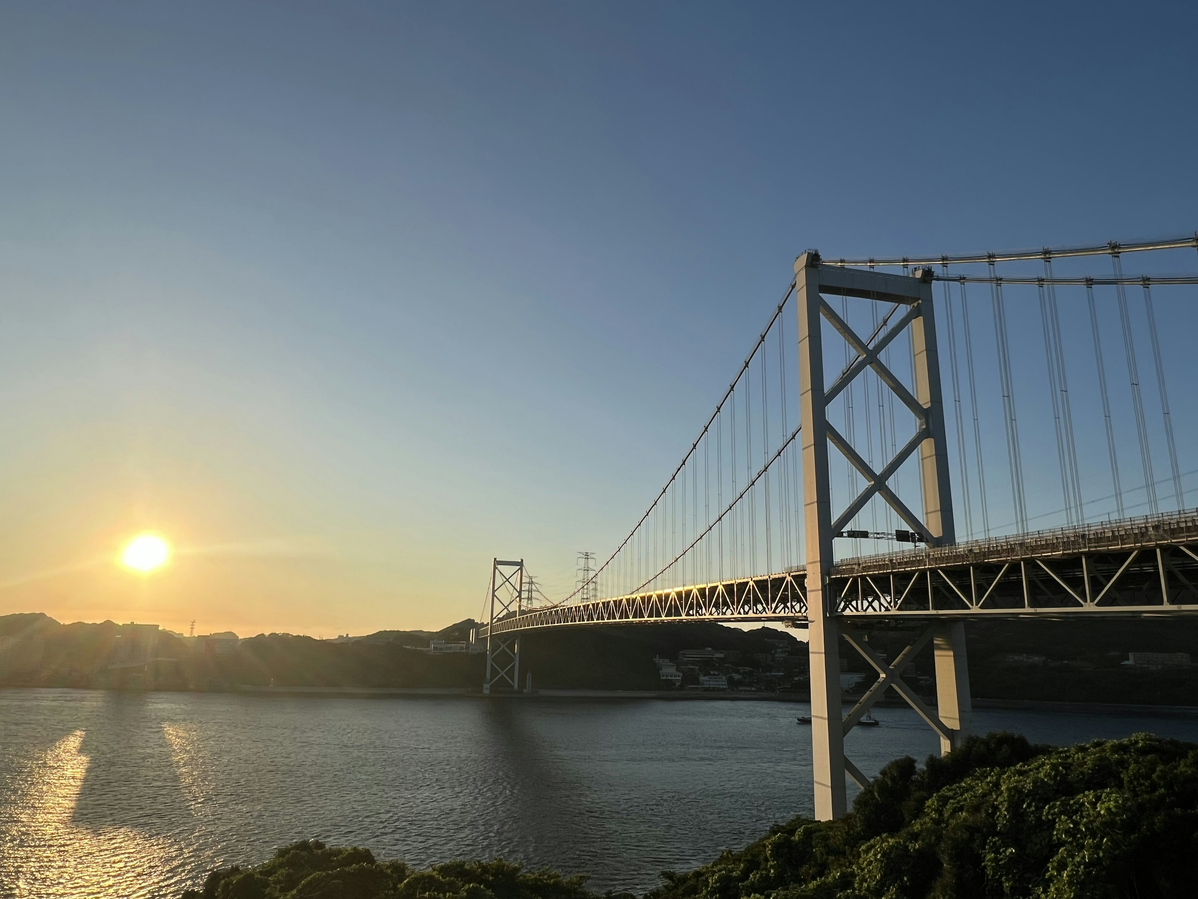 Schöne Aussicht auf eine Brücke über das Meer mit strahlendem Sonnenuntergang