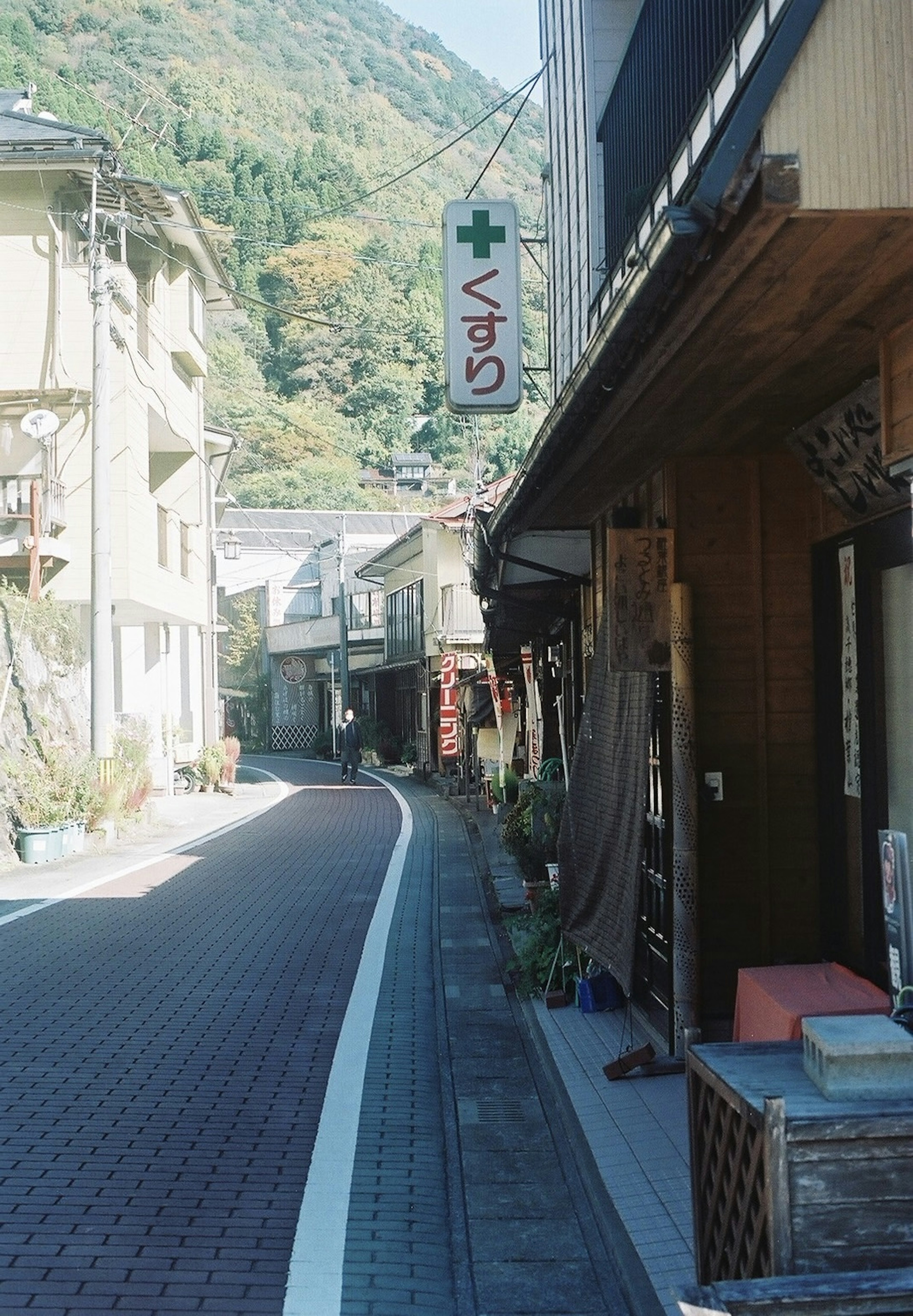 静かな街の通りに並ぶ建物と薬局の看板