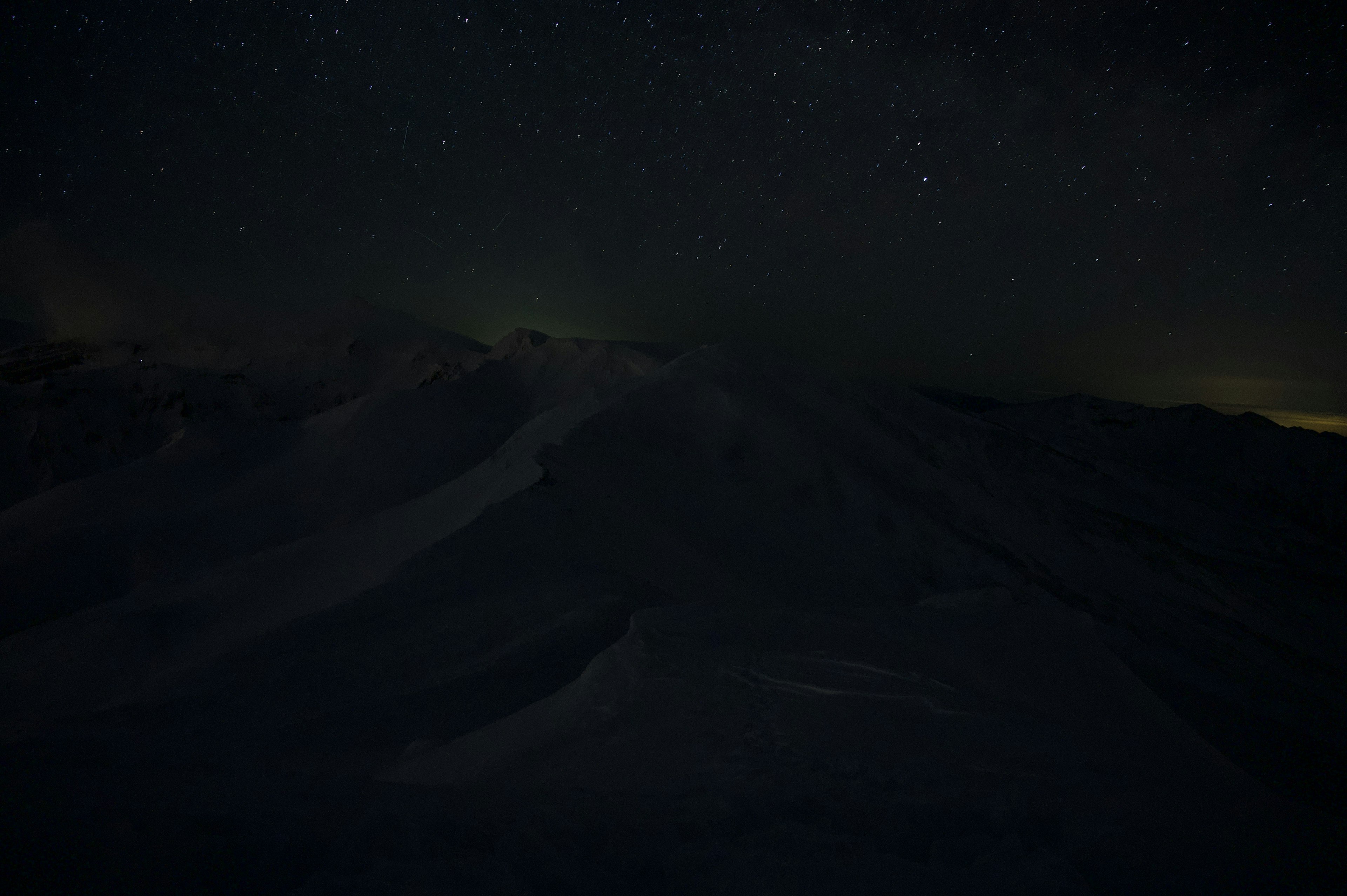 星空と暗い雪山の風景