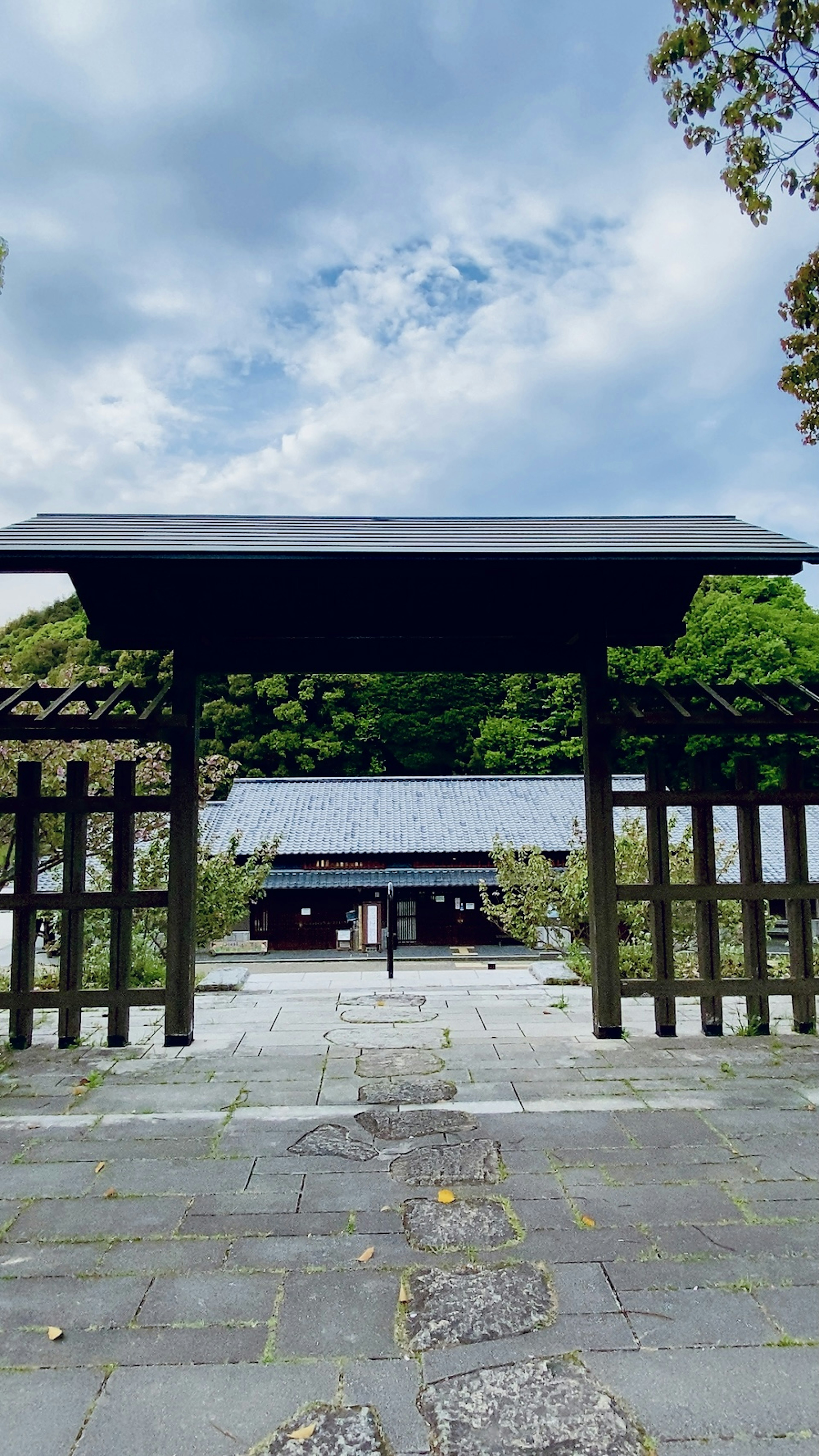 Black gate with a garden view under a blue sky