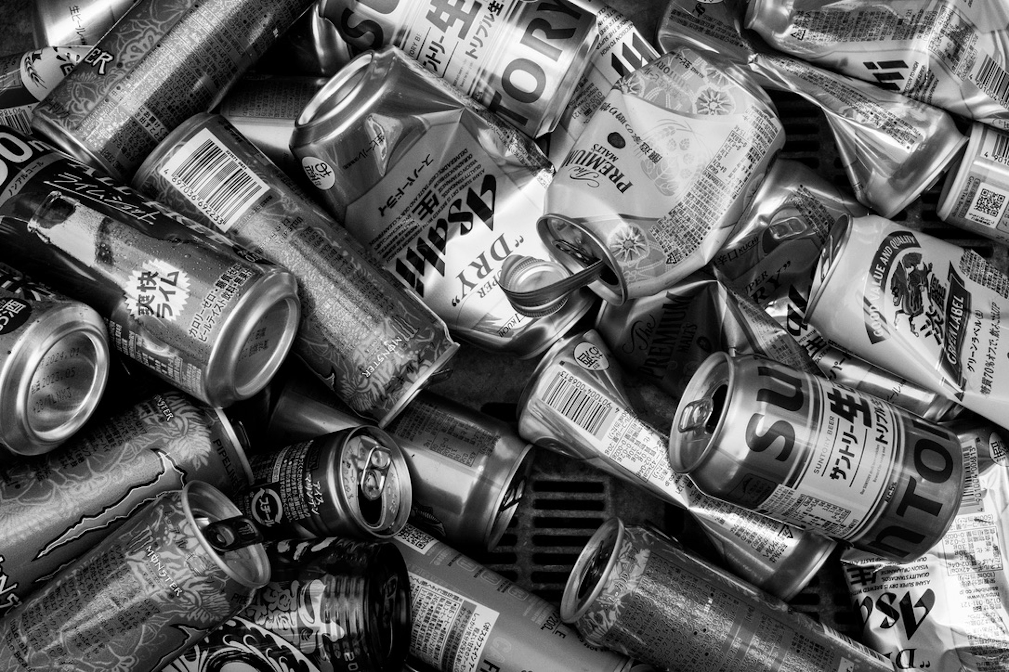 A pile of empty cans scattered in black and white