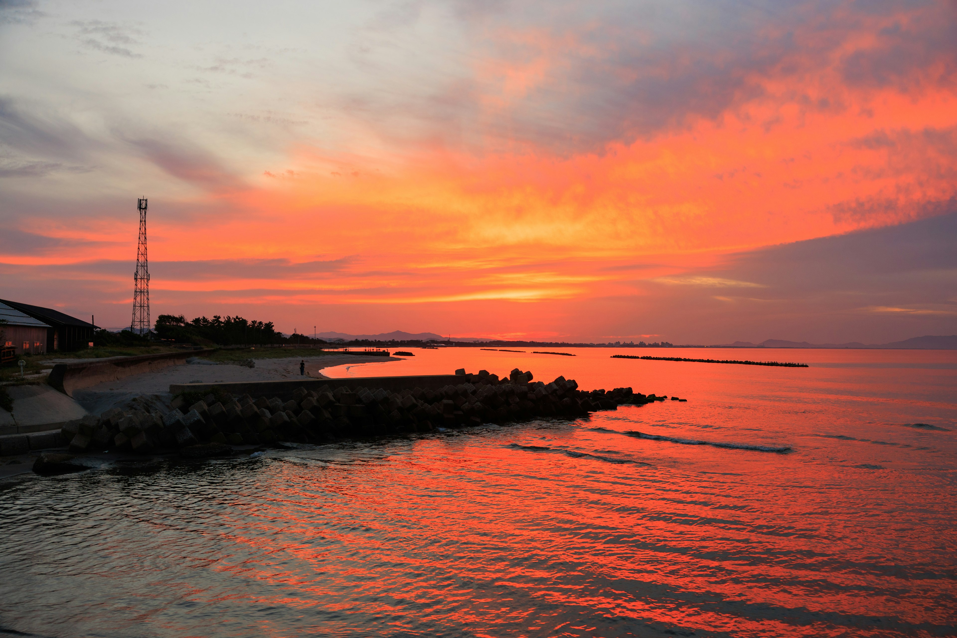 夕焼けの海岸線と穏やかな水面の風景