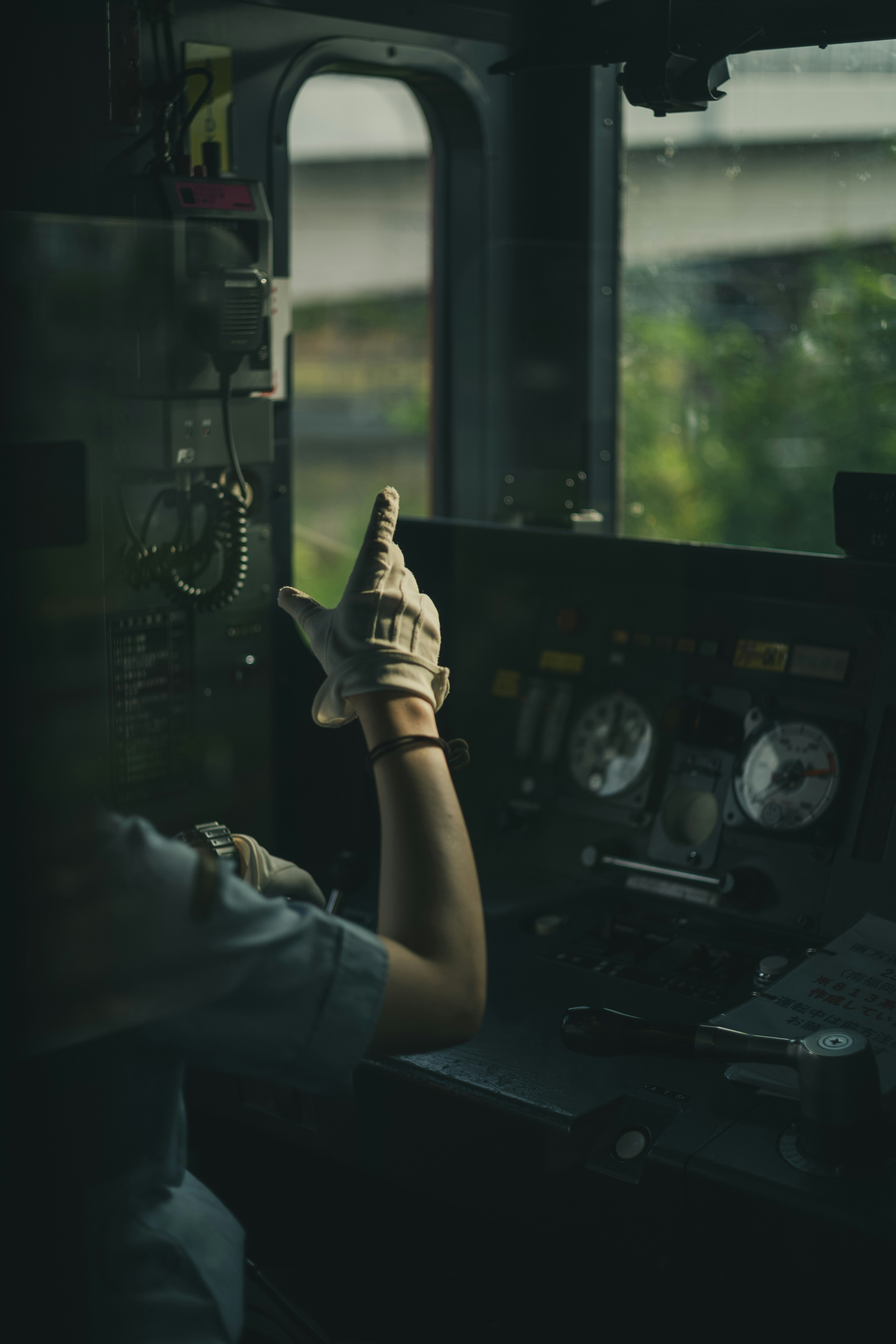 Un conducteur de train pointant depuis la cabine de contrôle