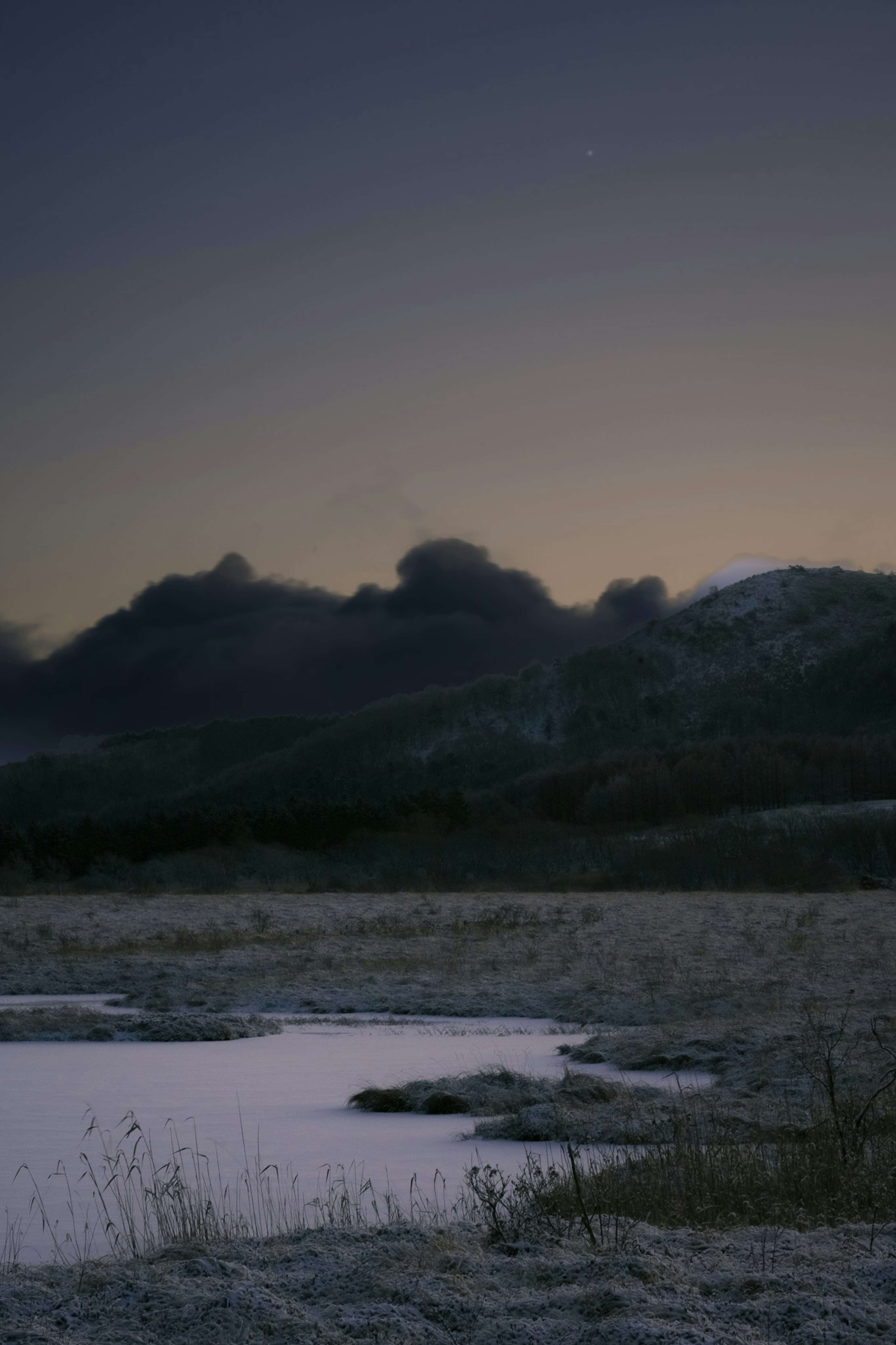 黄昏景观，雪地平原和远处的山脉