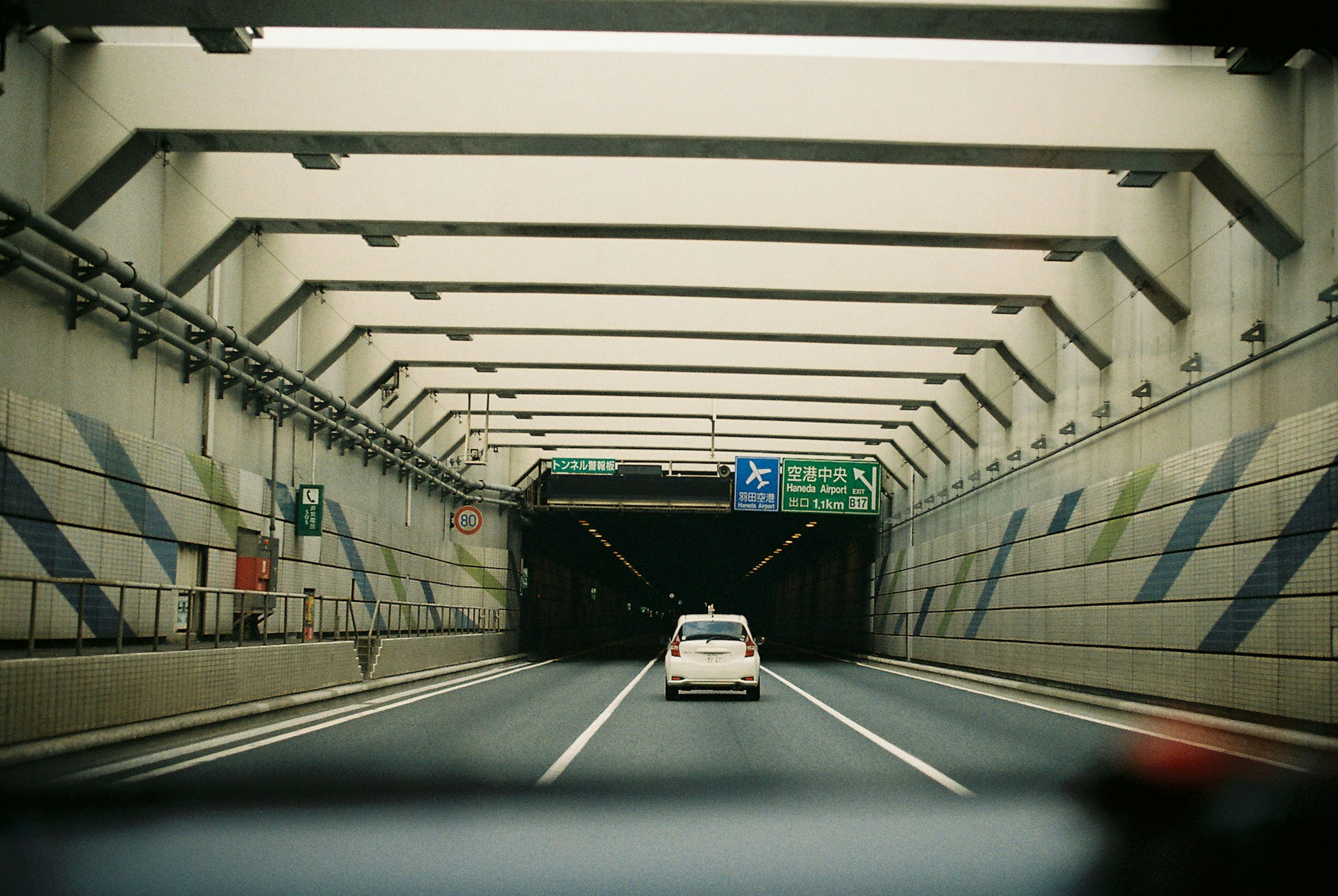 Fahrzeug fährt in einen Tunnel mit architektonischen Details darüber