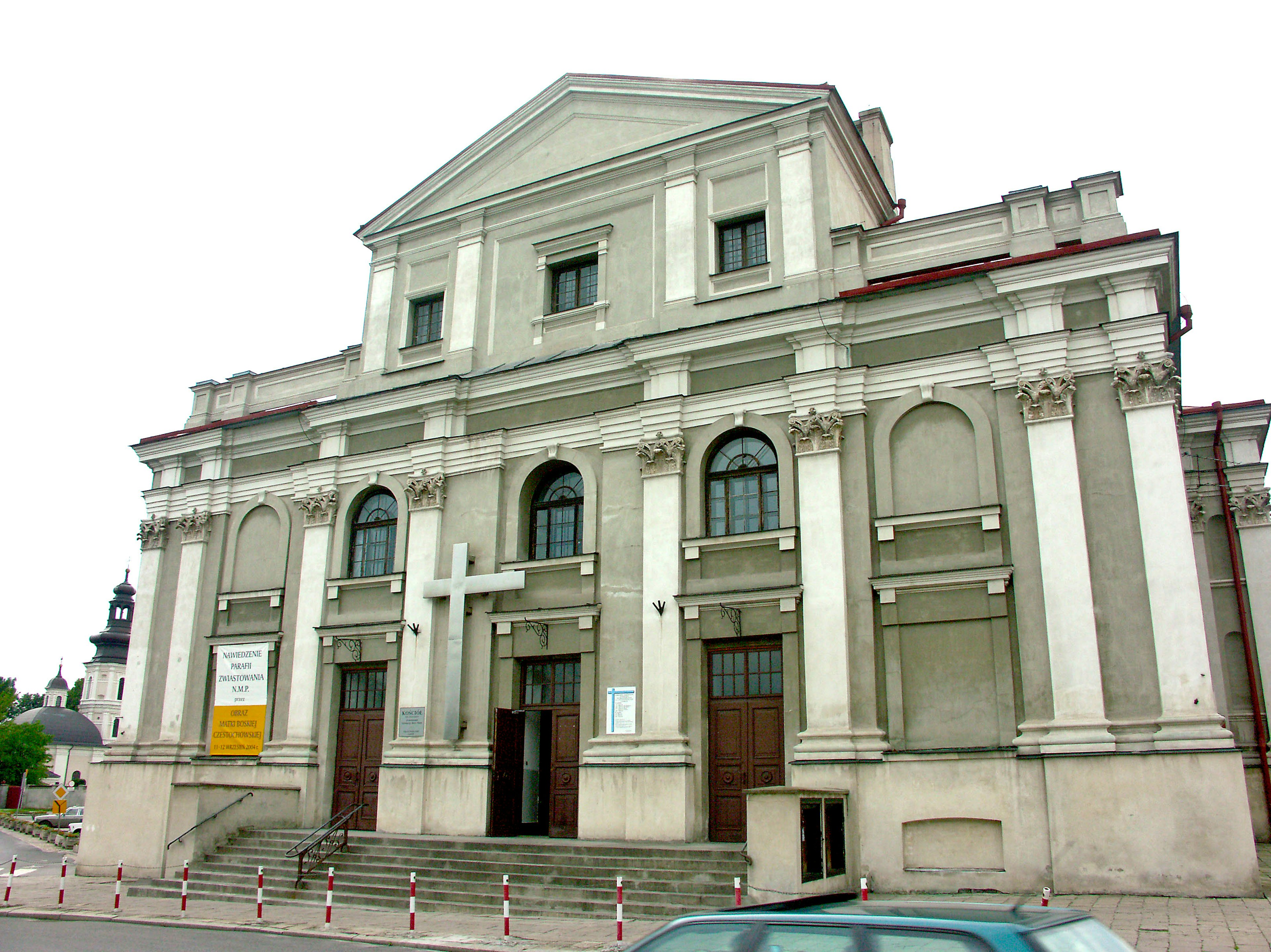 Façade d'une église de style classique avec des murs blancs et des colonnes décoratives