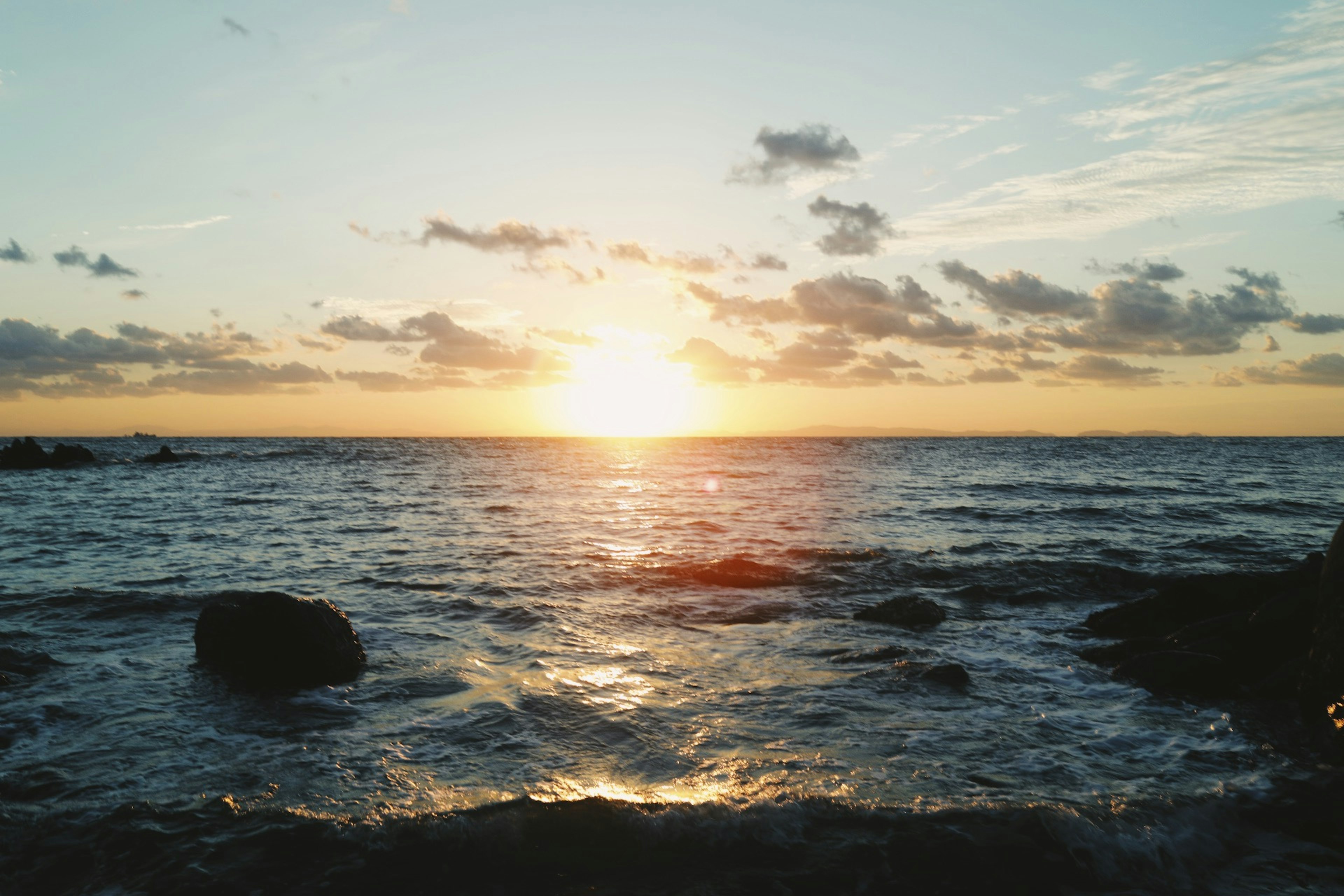 夕日が海に沈む美しい風景 岩が点在する海岸