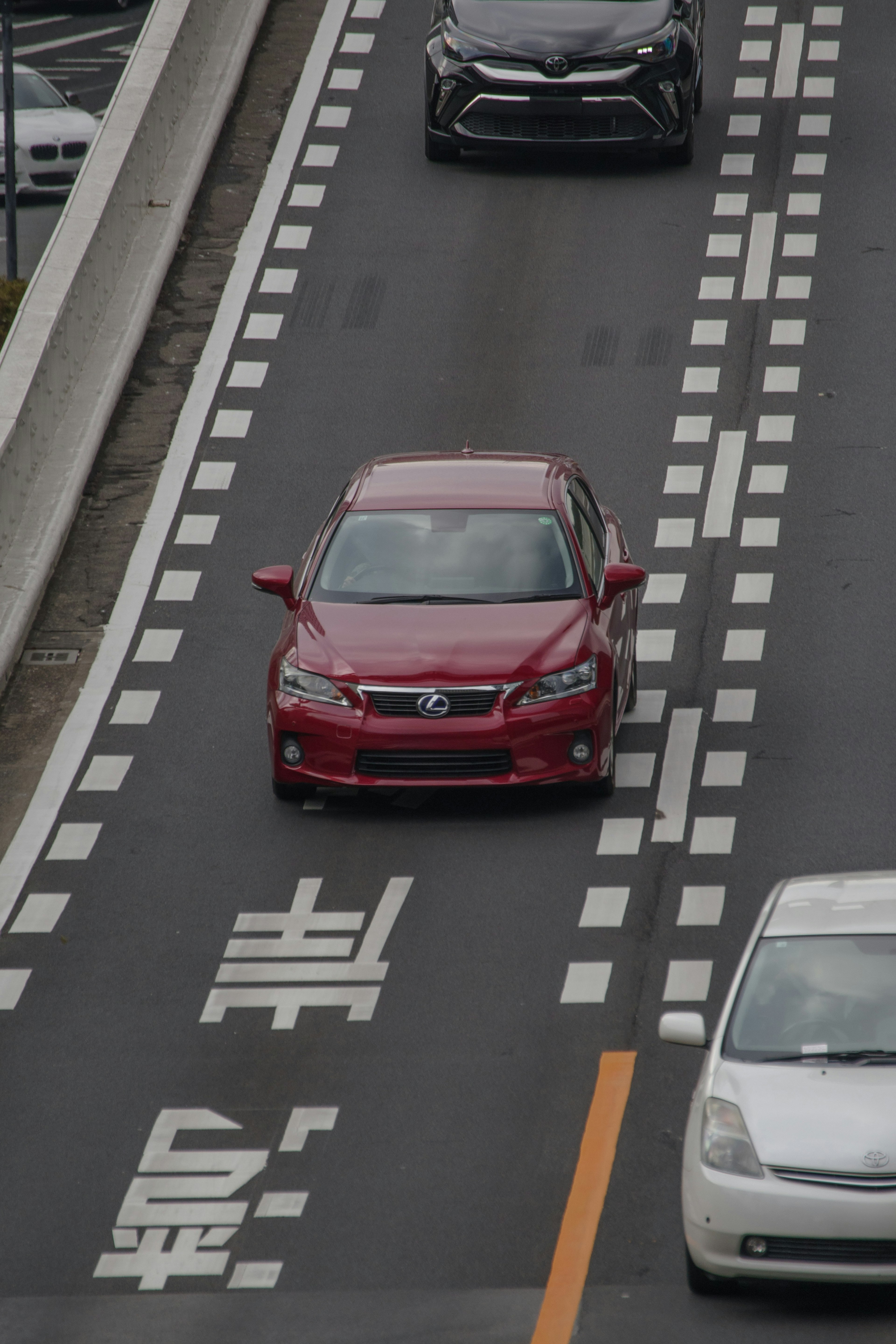 一辆红色汽车在有车道标记的道路上行驶