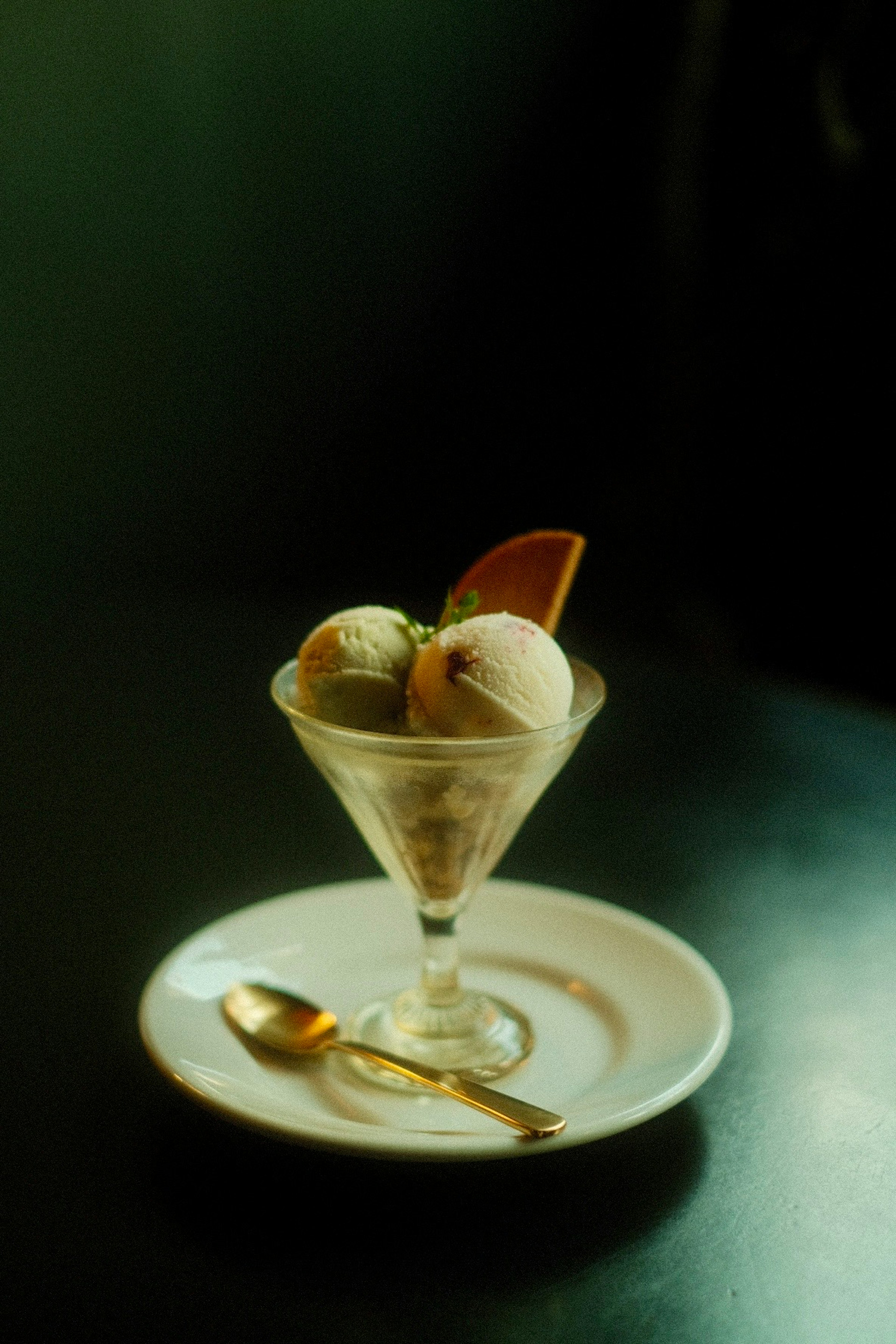 A crystal glass filled with ice cream and a slice of orange