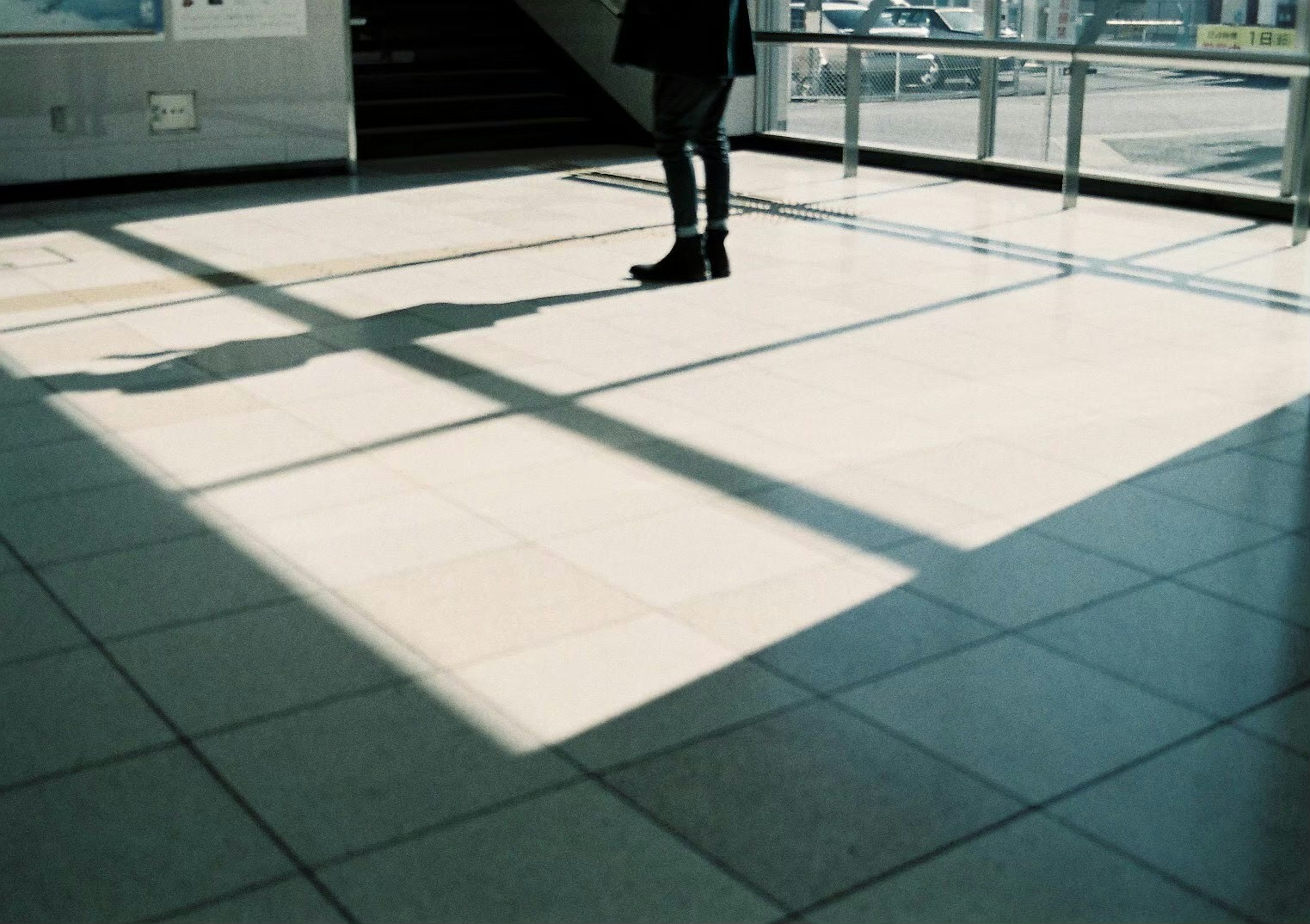 Silhouette of a person on tiled floor with shadows