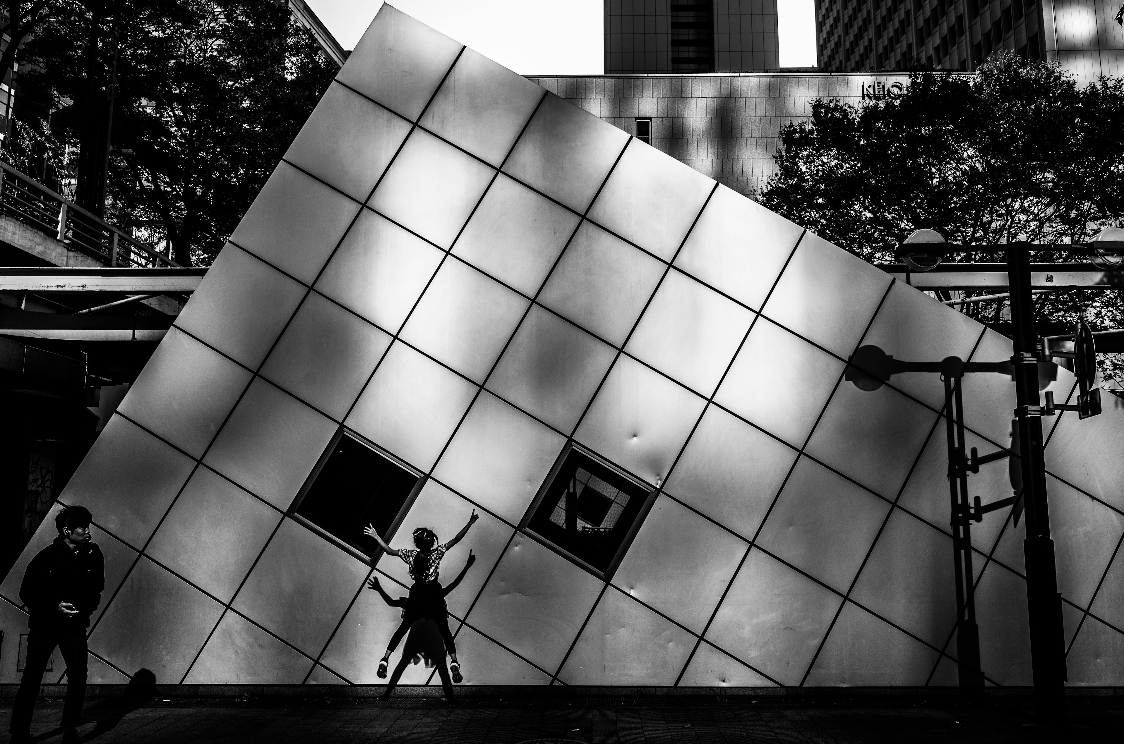 Tilted modern building with silhouetted figures