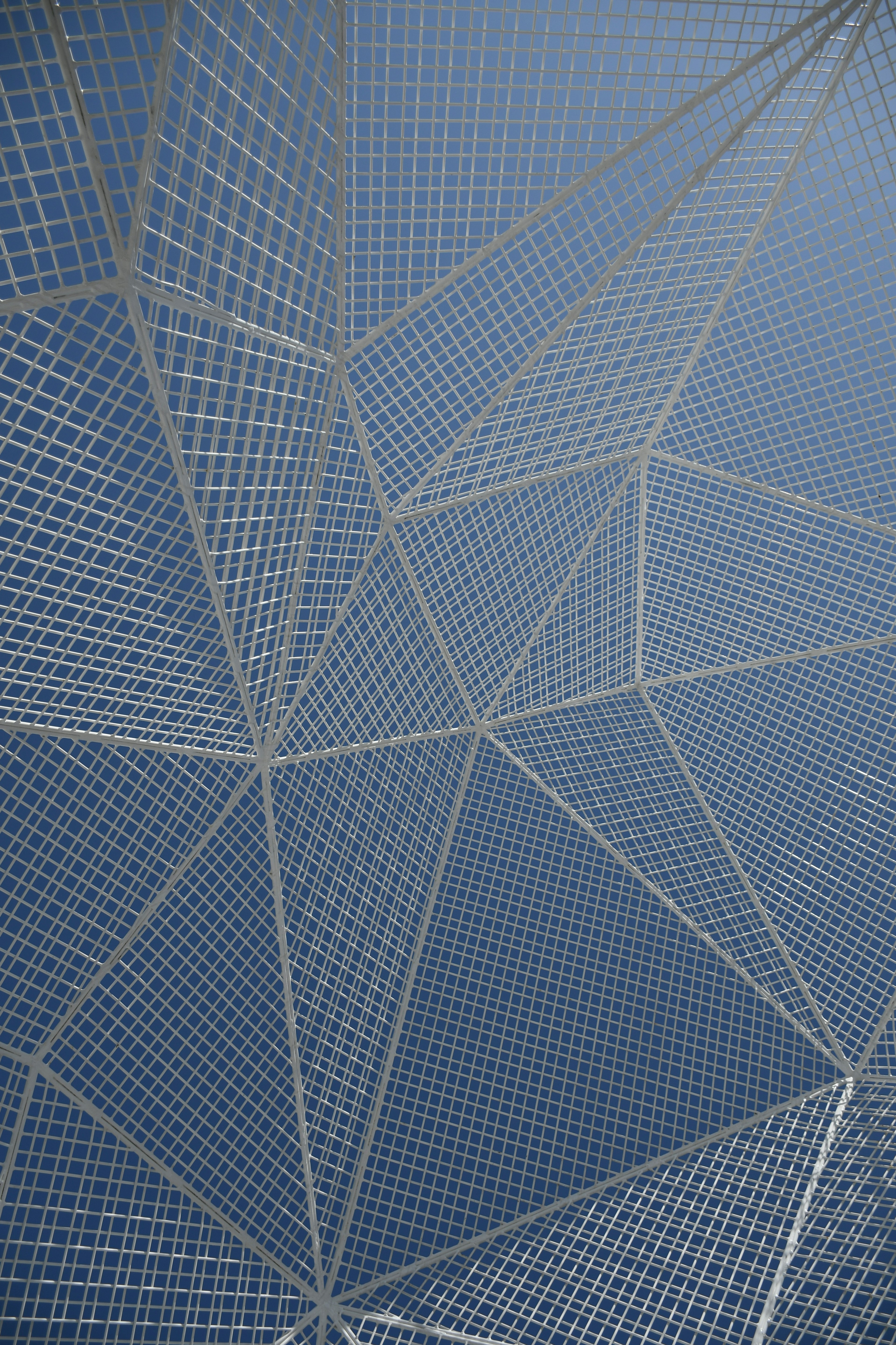 Geometric white mesh pattern under blue sky