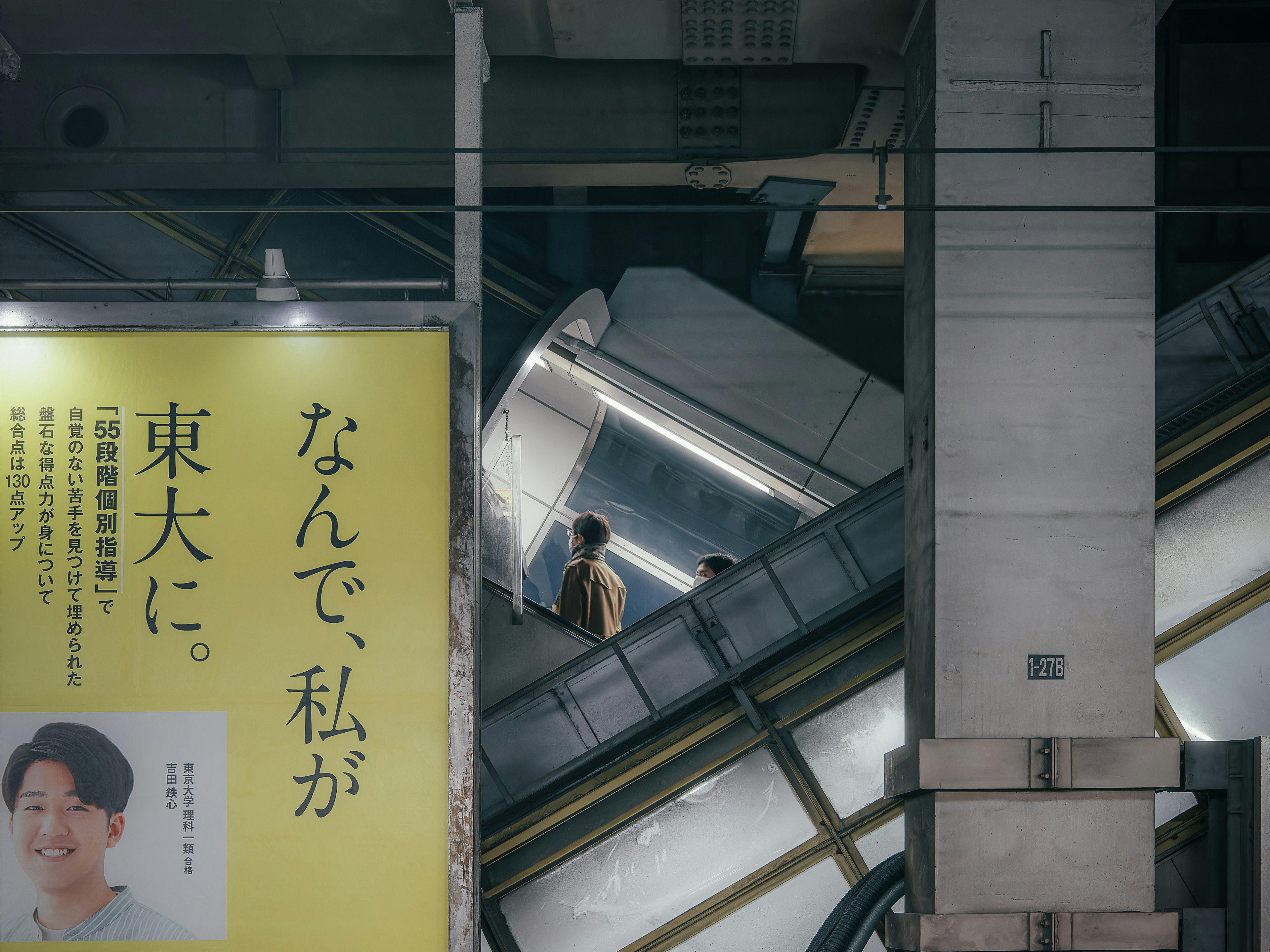 Des gens montant un escalier roulant dans une station de métro avec une publicité visible