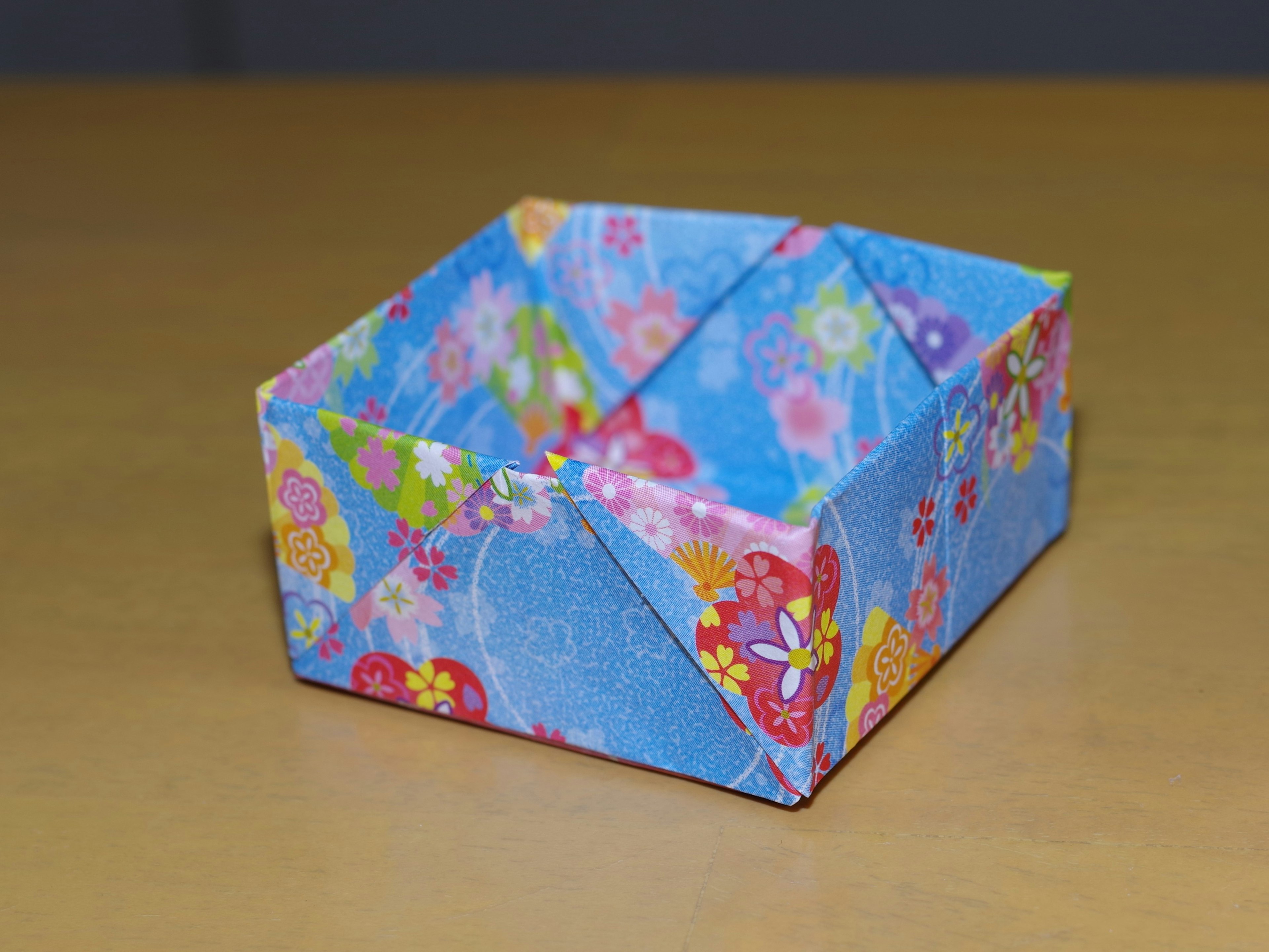 A blue floral origami box placed on a table