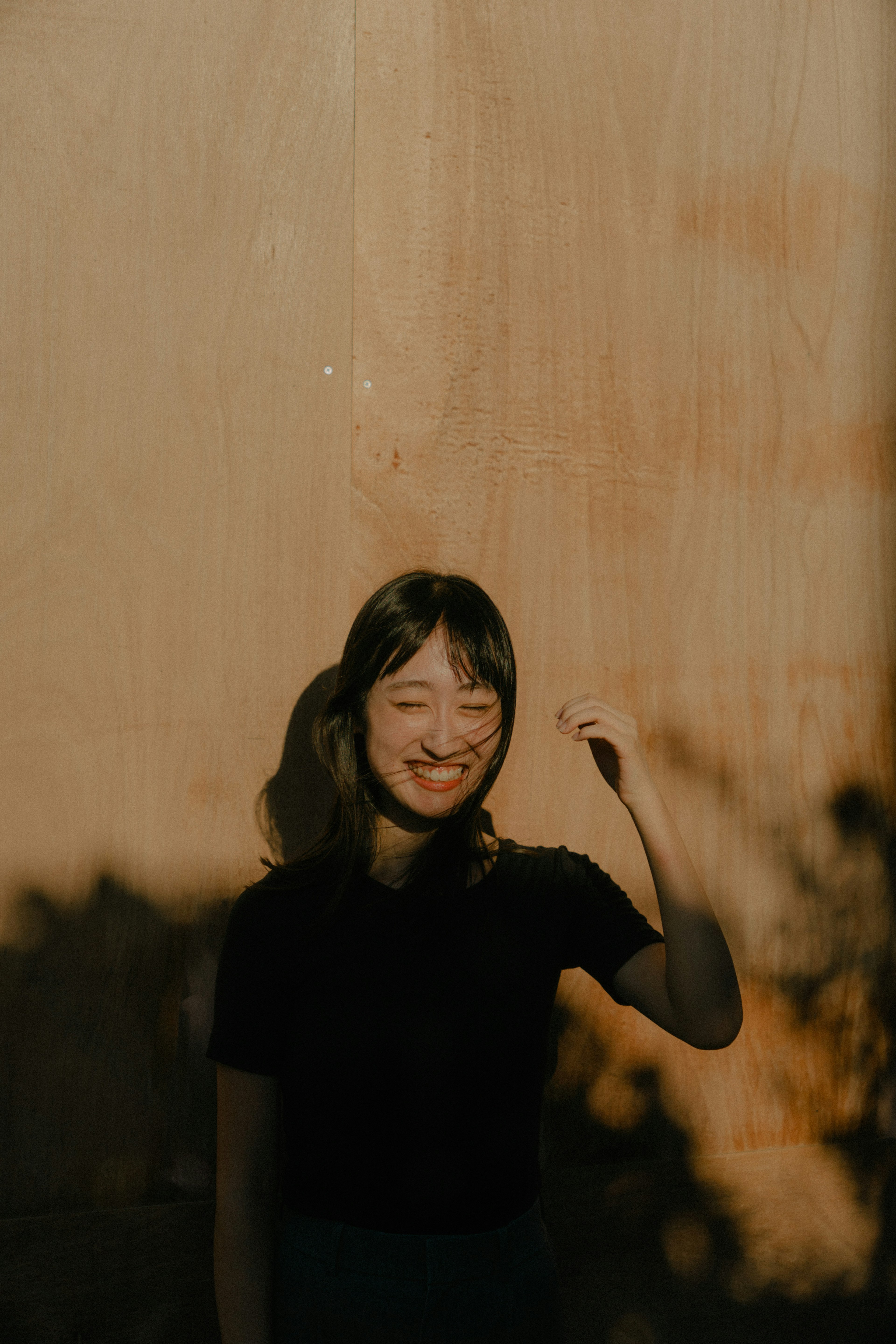 Ritratto di una donna sorridente davanti a un muro di legno