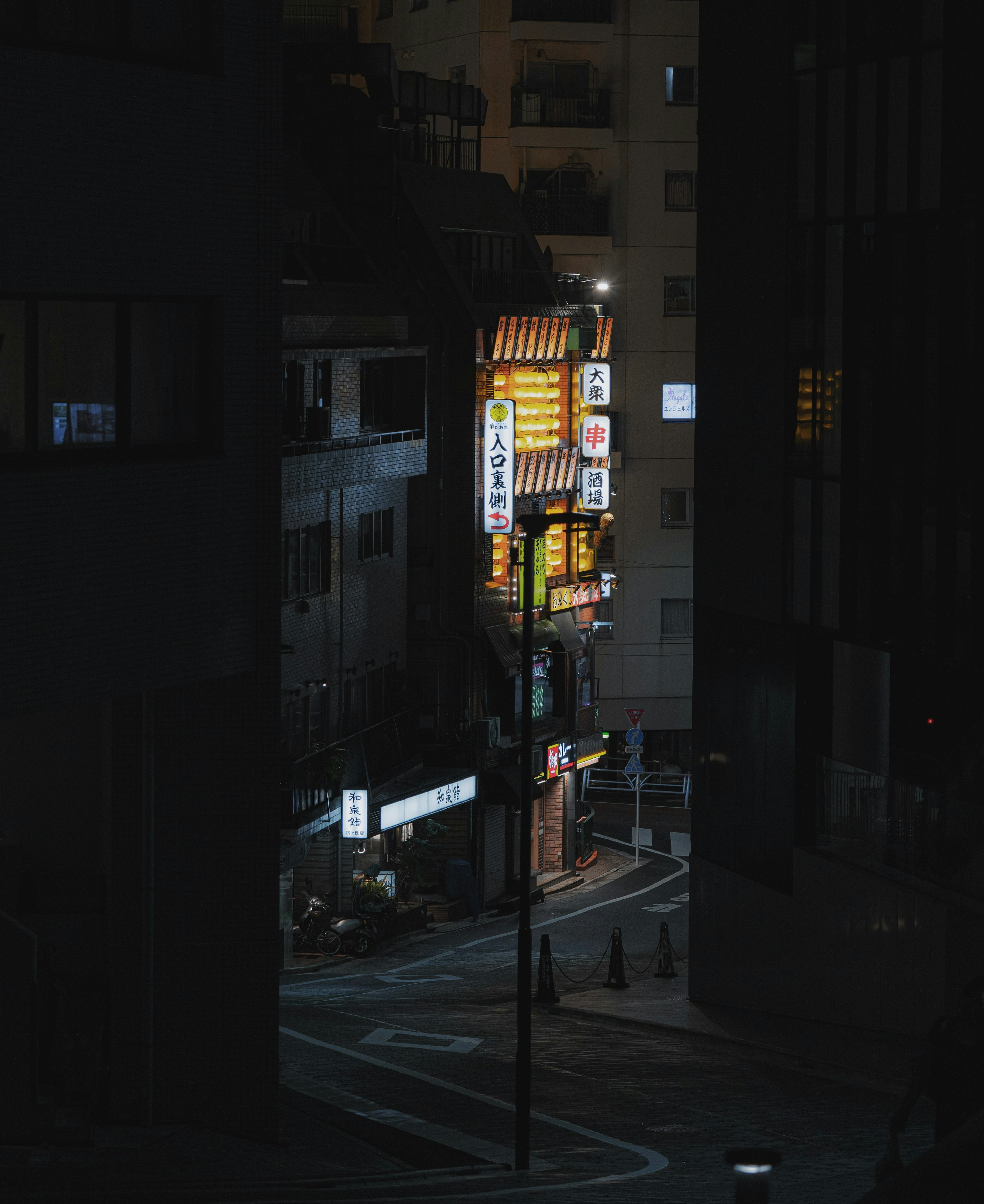 夜の街角の看板が光る暗い通り