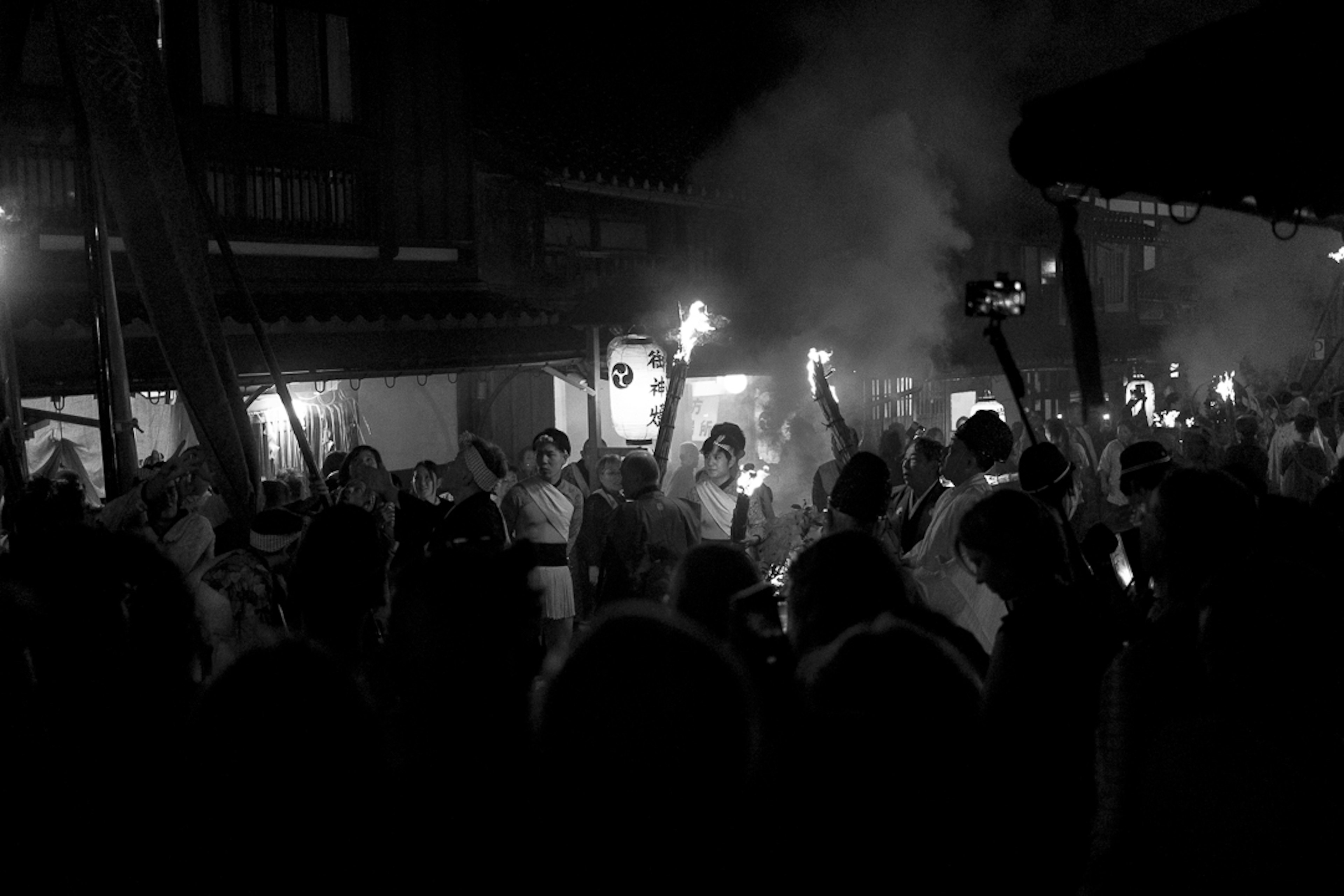 Multitud sosteniendo antorchas durante un festival nocturno