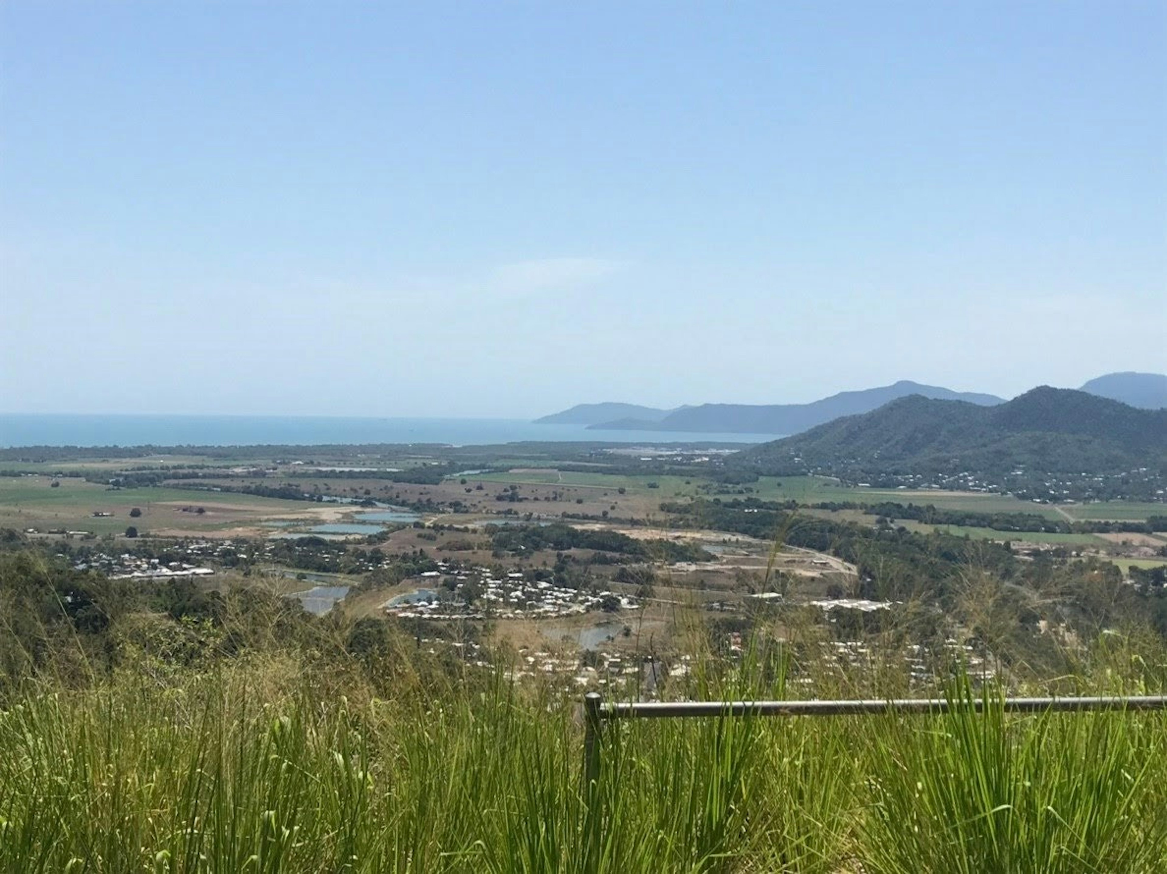 Vista escénica del océano y montañas con hierba verde