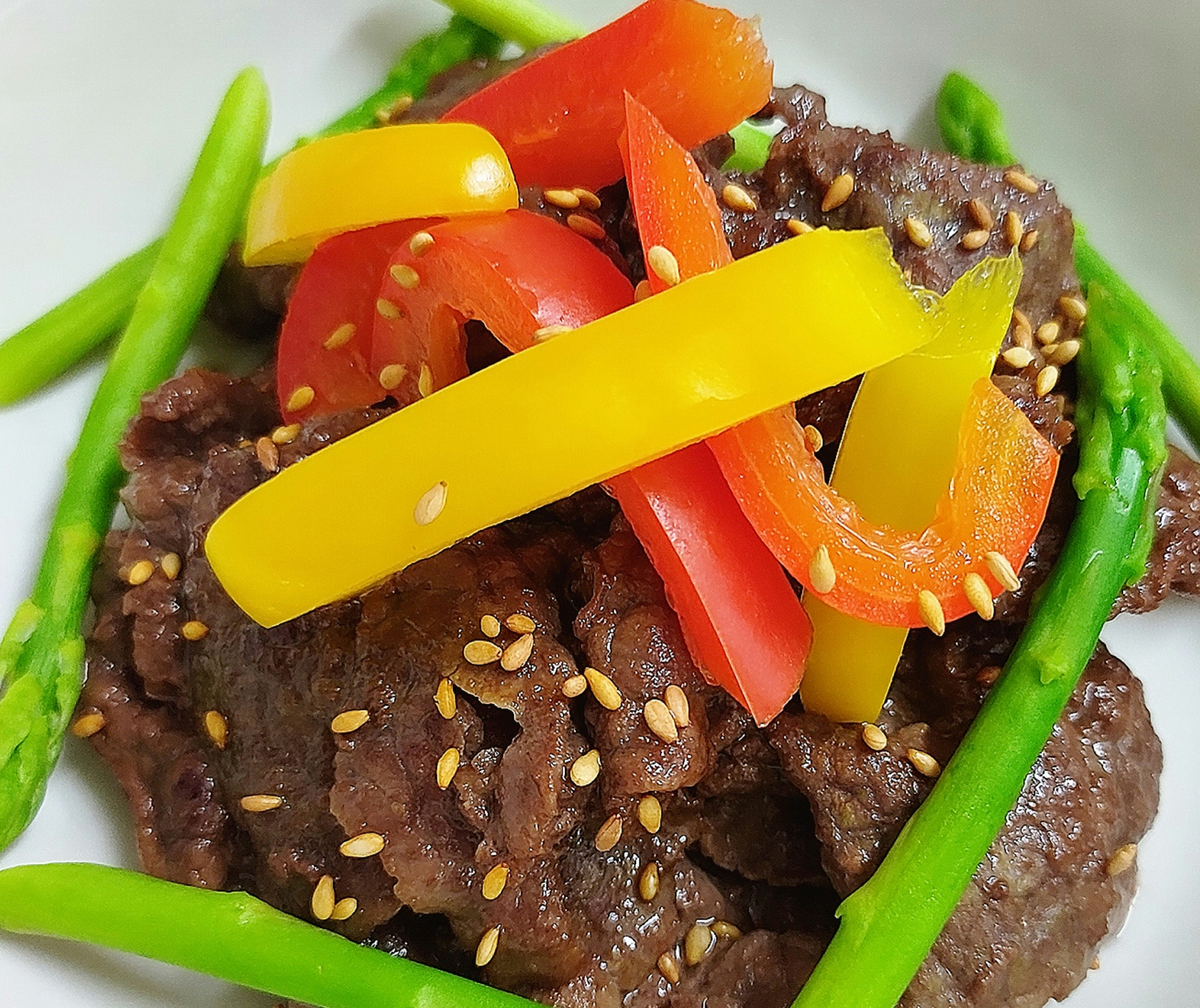 Colorful bell peppers atop spicy sweet beef dish