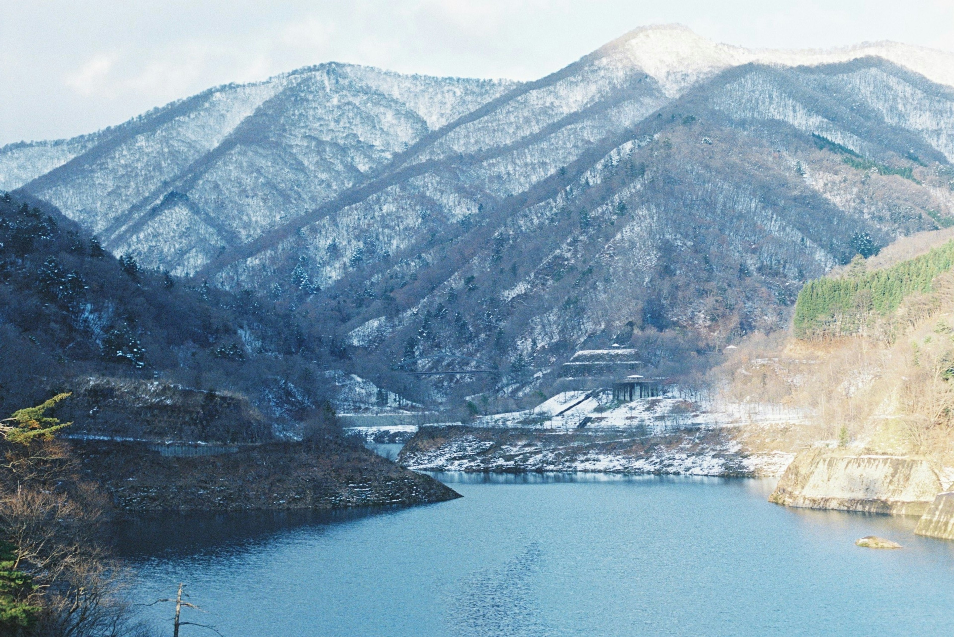 雪に覆われた山々と静かな湖の風景