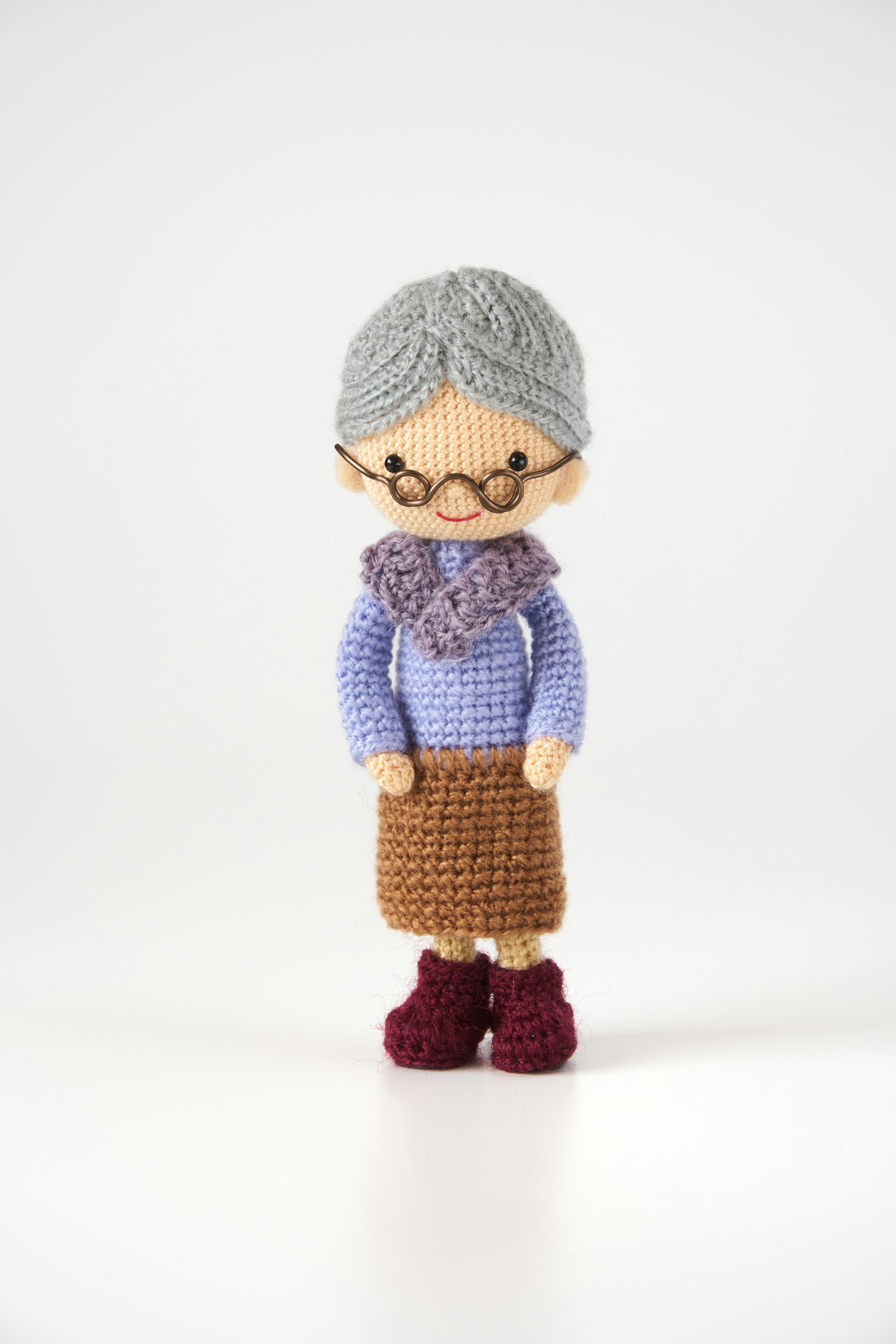 A cute crocheted grandmother doll standing upright