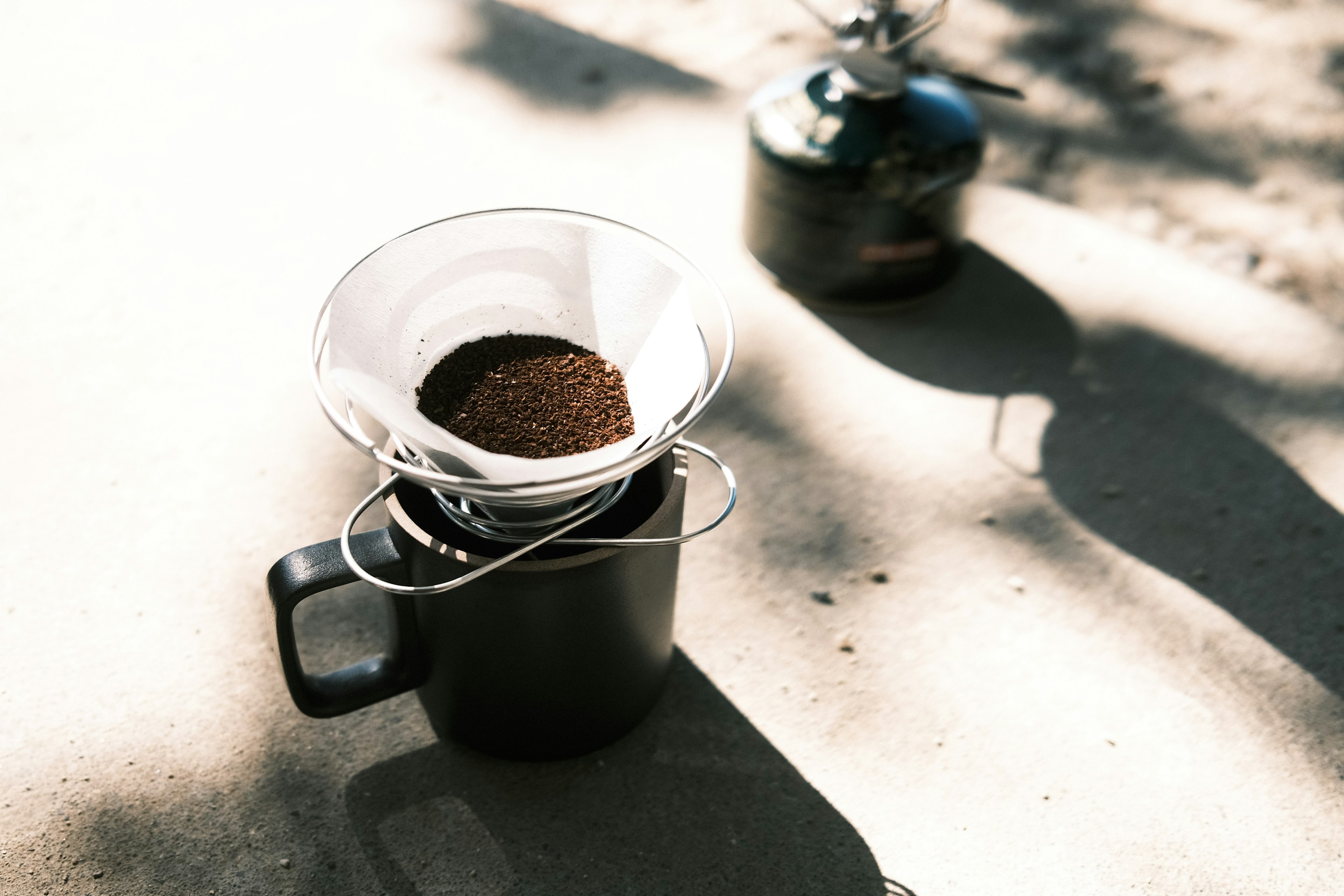 Coffee dripper with ground coffee placed on a black mug