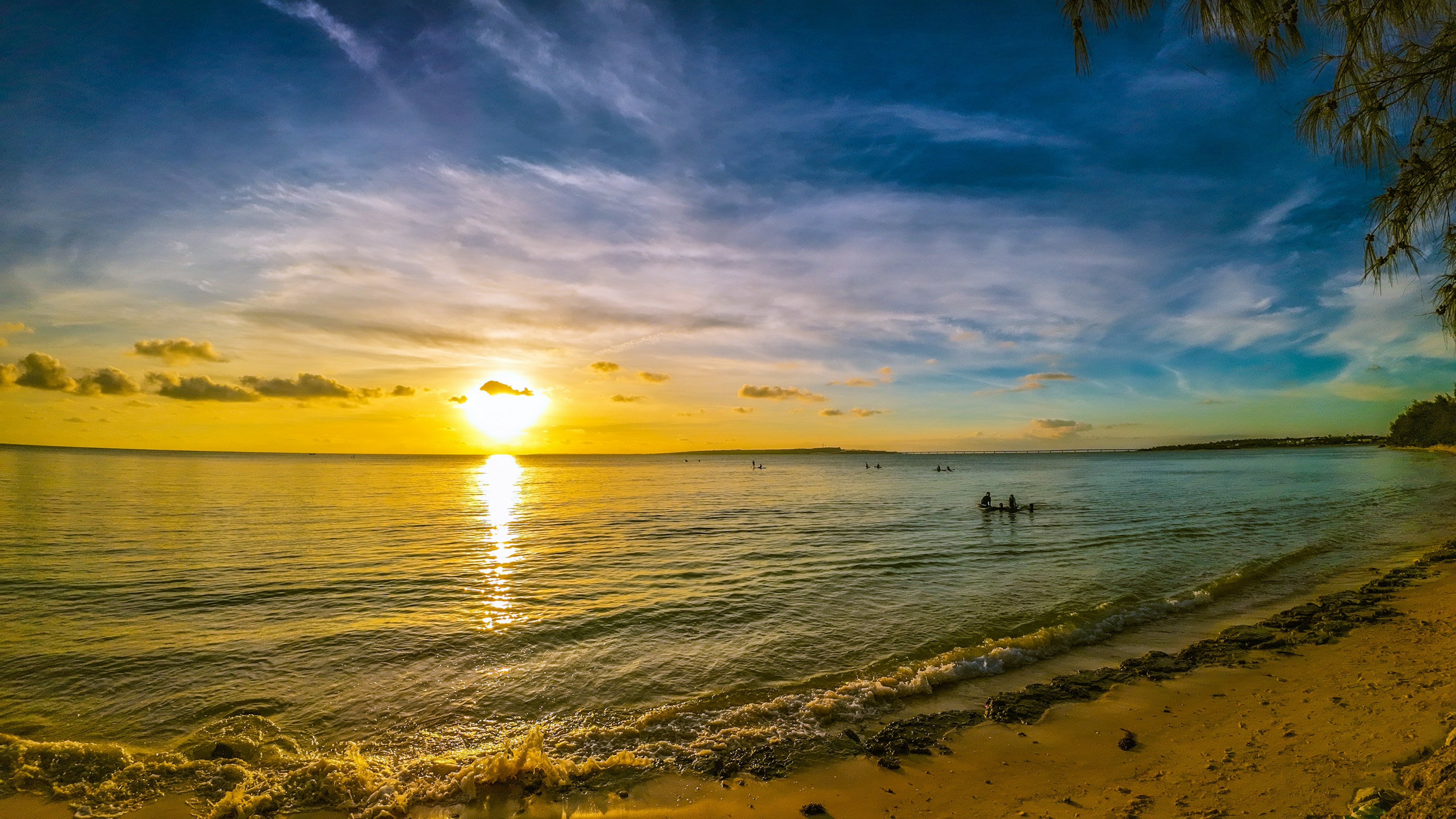 Pemandangan pantai matahari terbenam yang indah air tenang dan matahari kuning