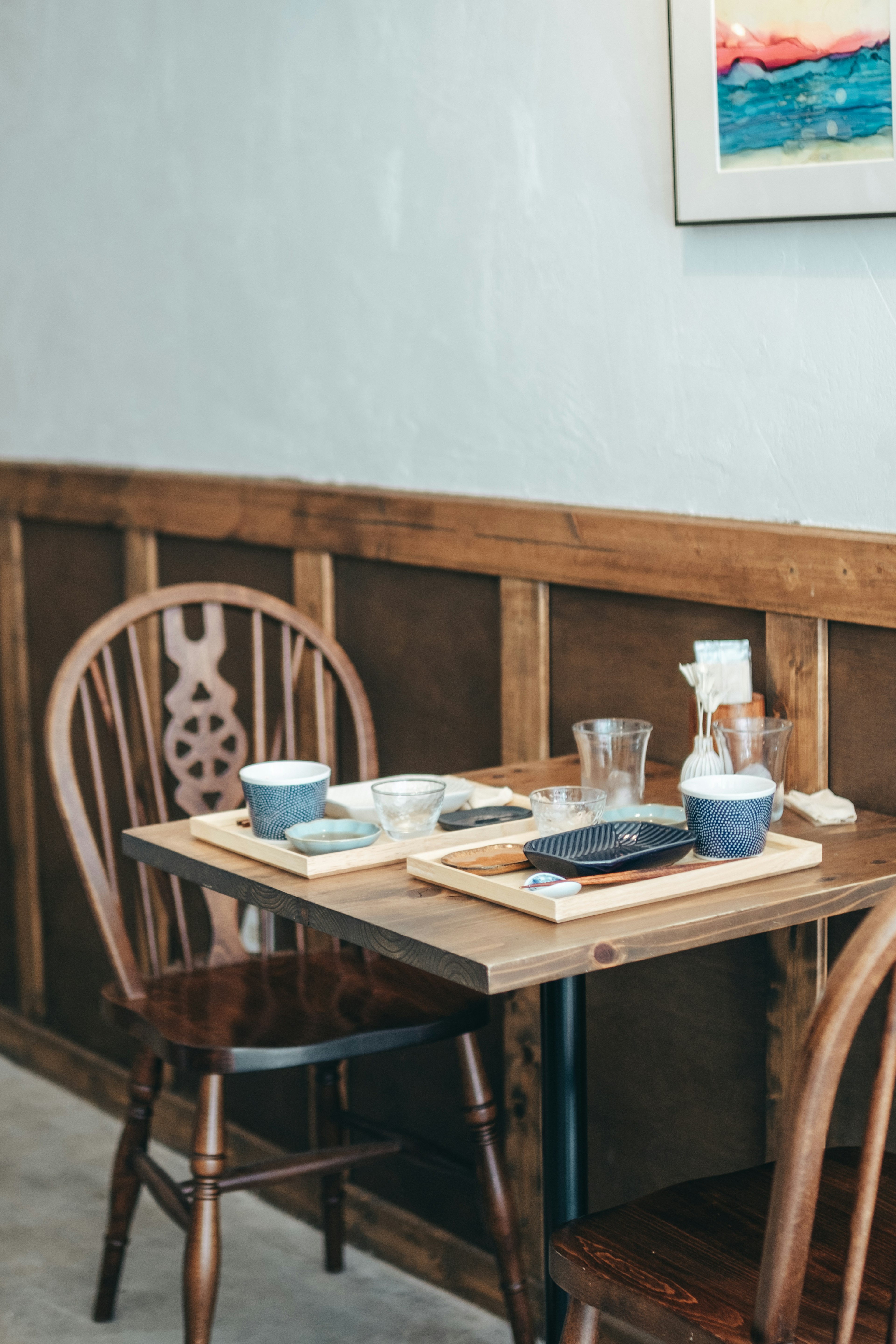 Cozy restaurant corner with wooden table and chairs featuring tableware and glasses