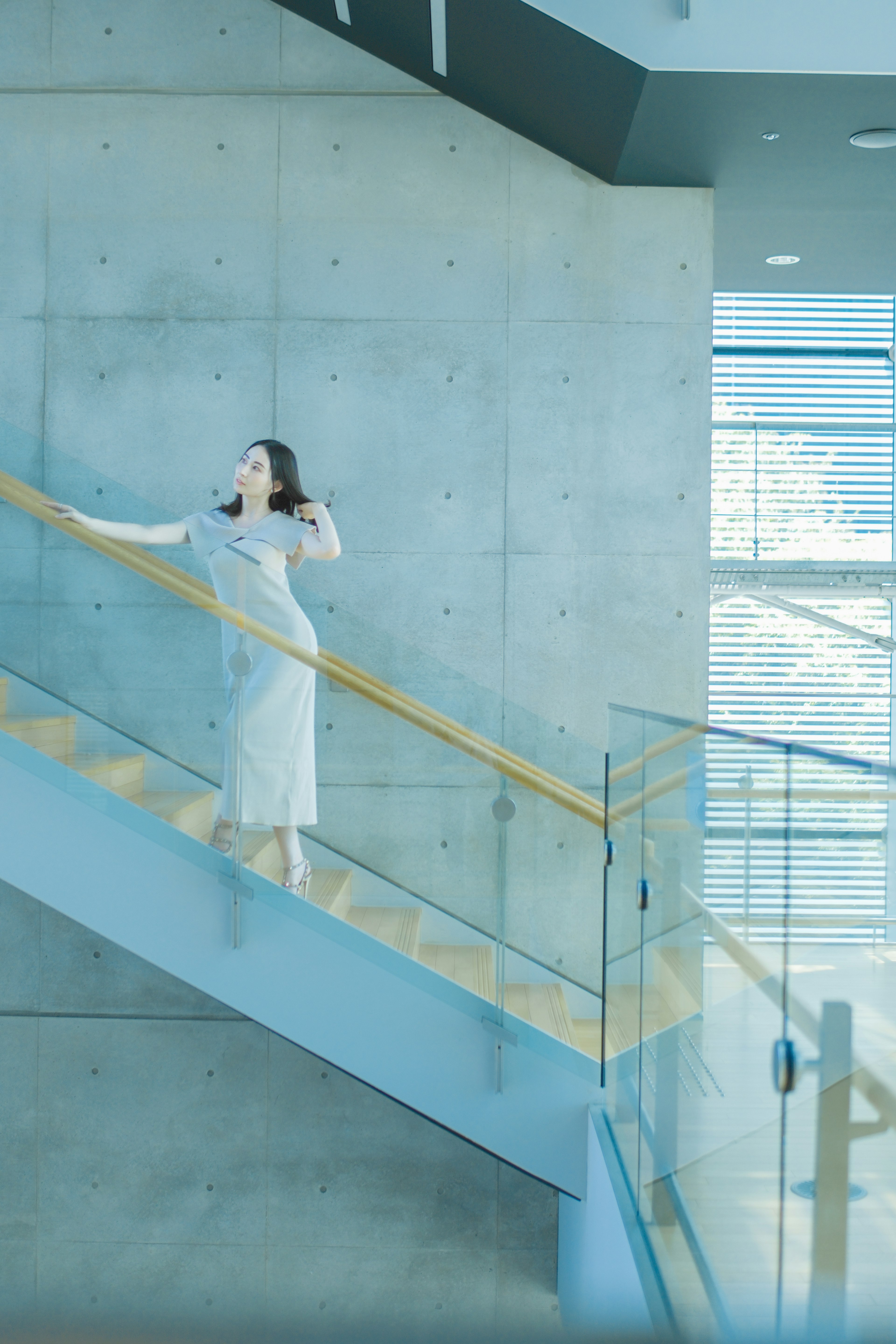 Eine Frau, die eine moderne Treppe in einem zeitgenössischen Gebäude hinaufsteigt