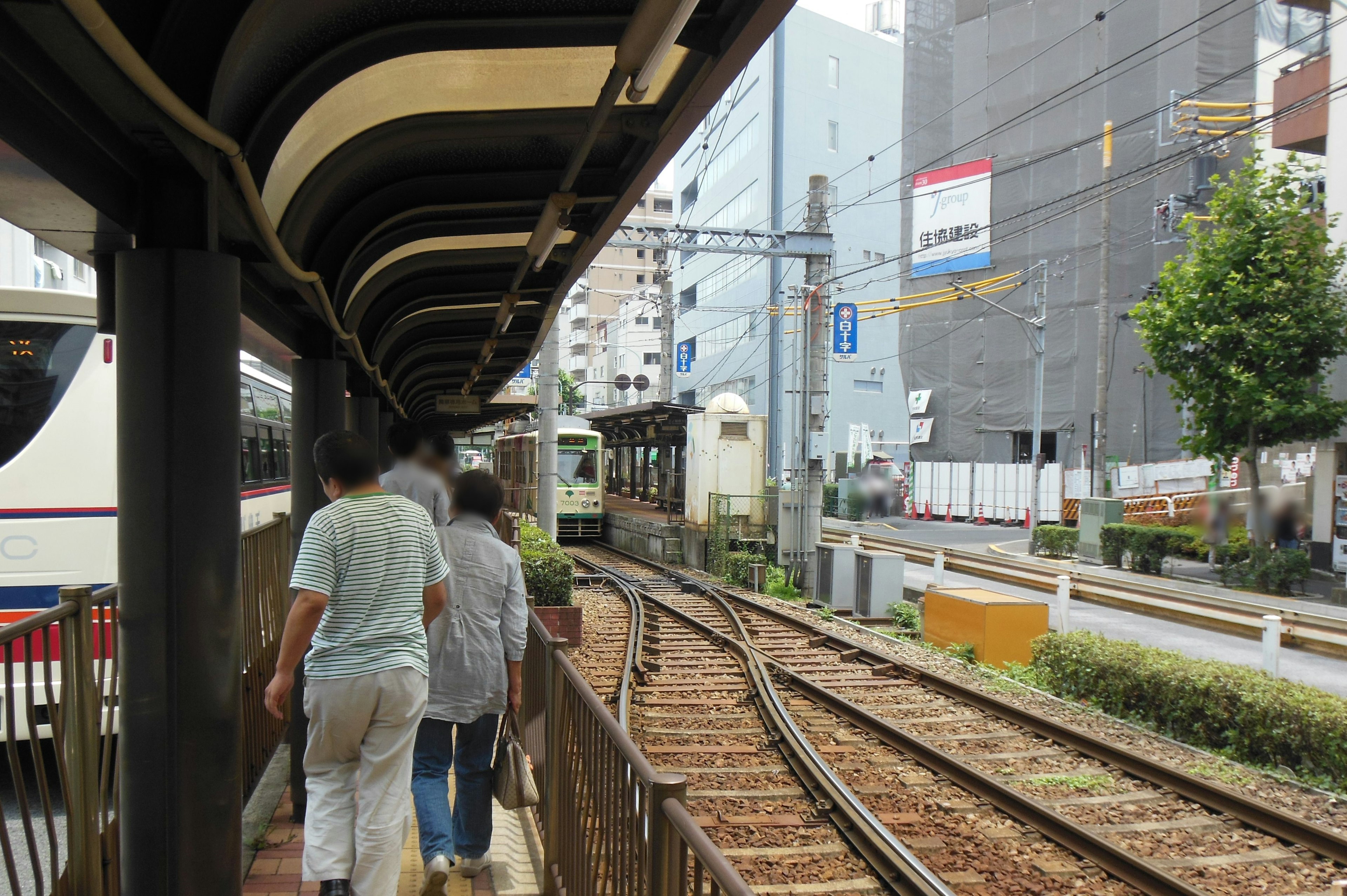 駅のプラットフォームで歩く人々と線路の風景