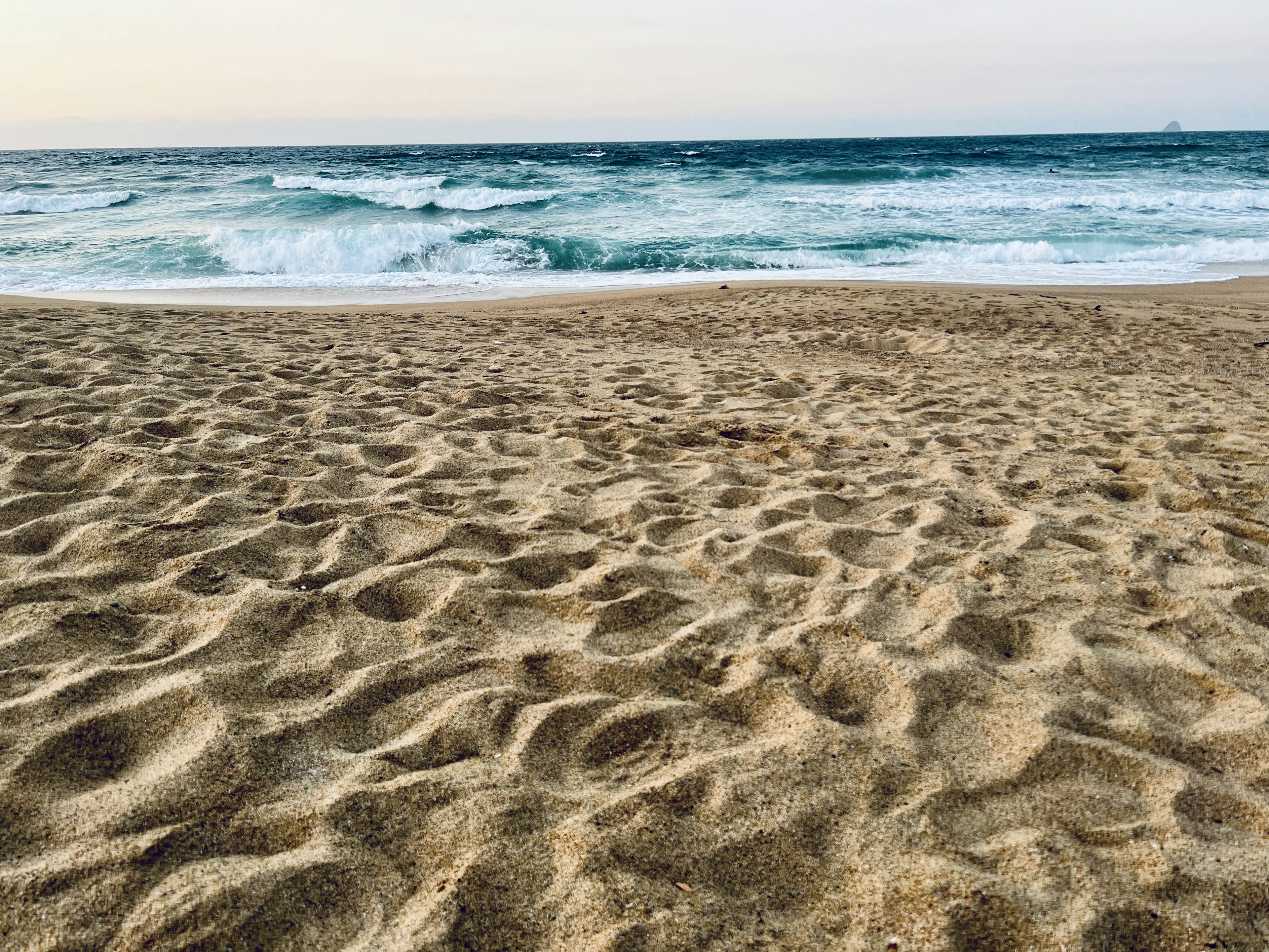 ทิวทัศน์ชายหาดที่มีทรายและคลื่นทะเล