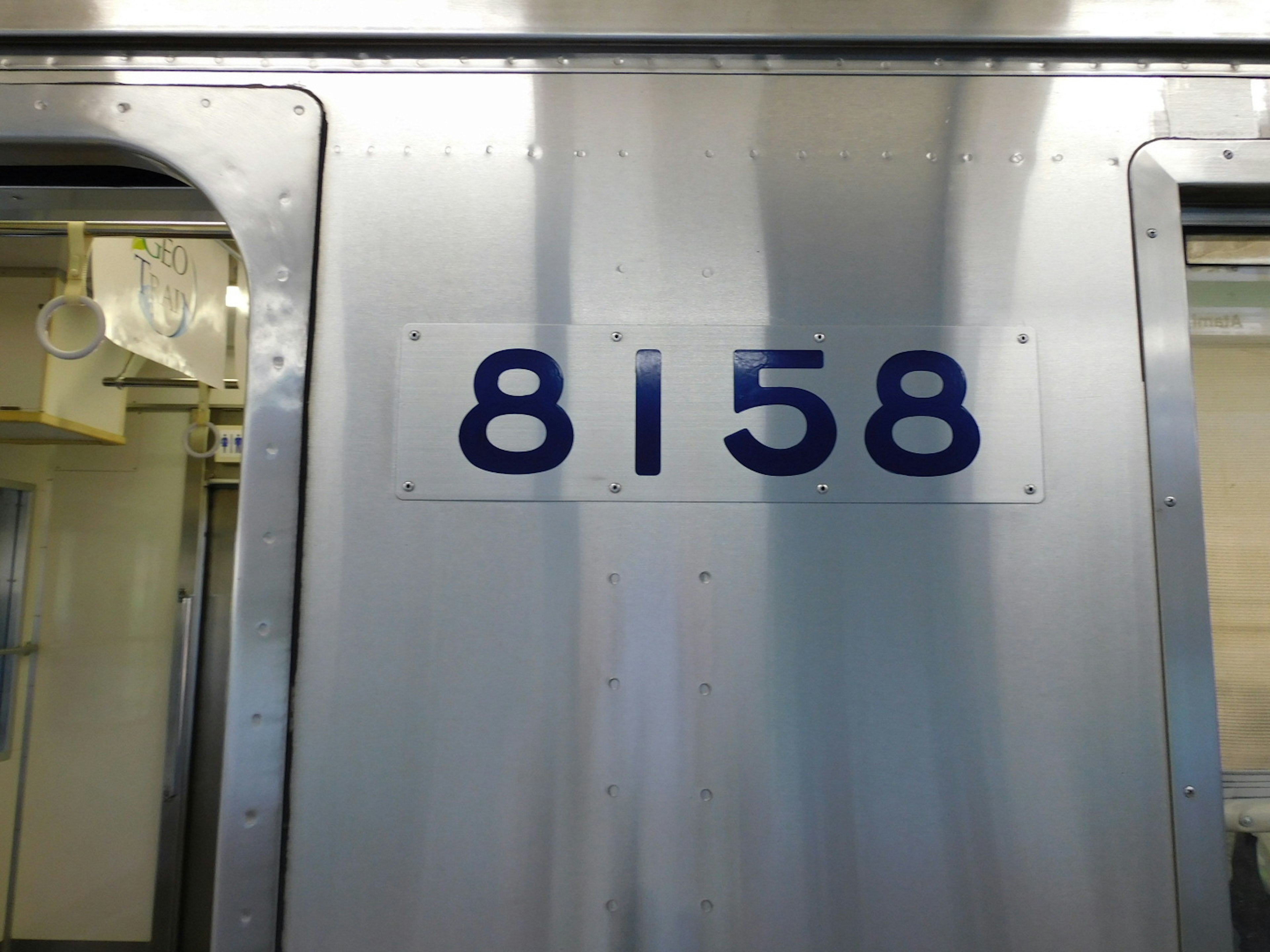 Metal side of a train car displaying the number 8158