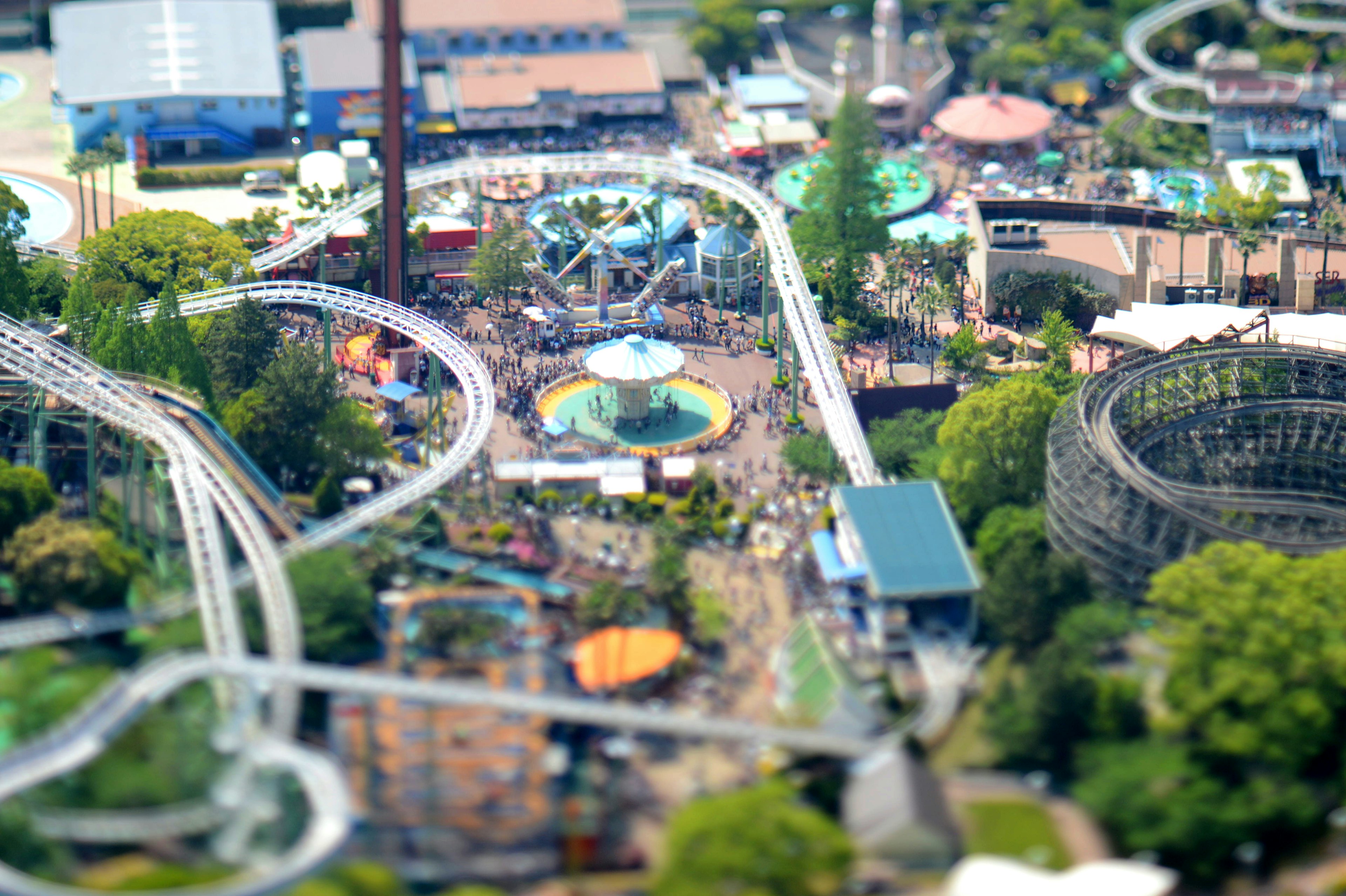 Aerial view of an amusement park featuring rides and green trees