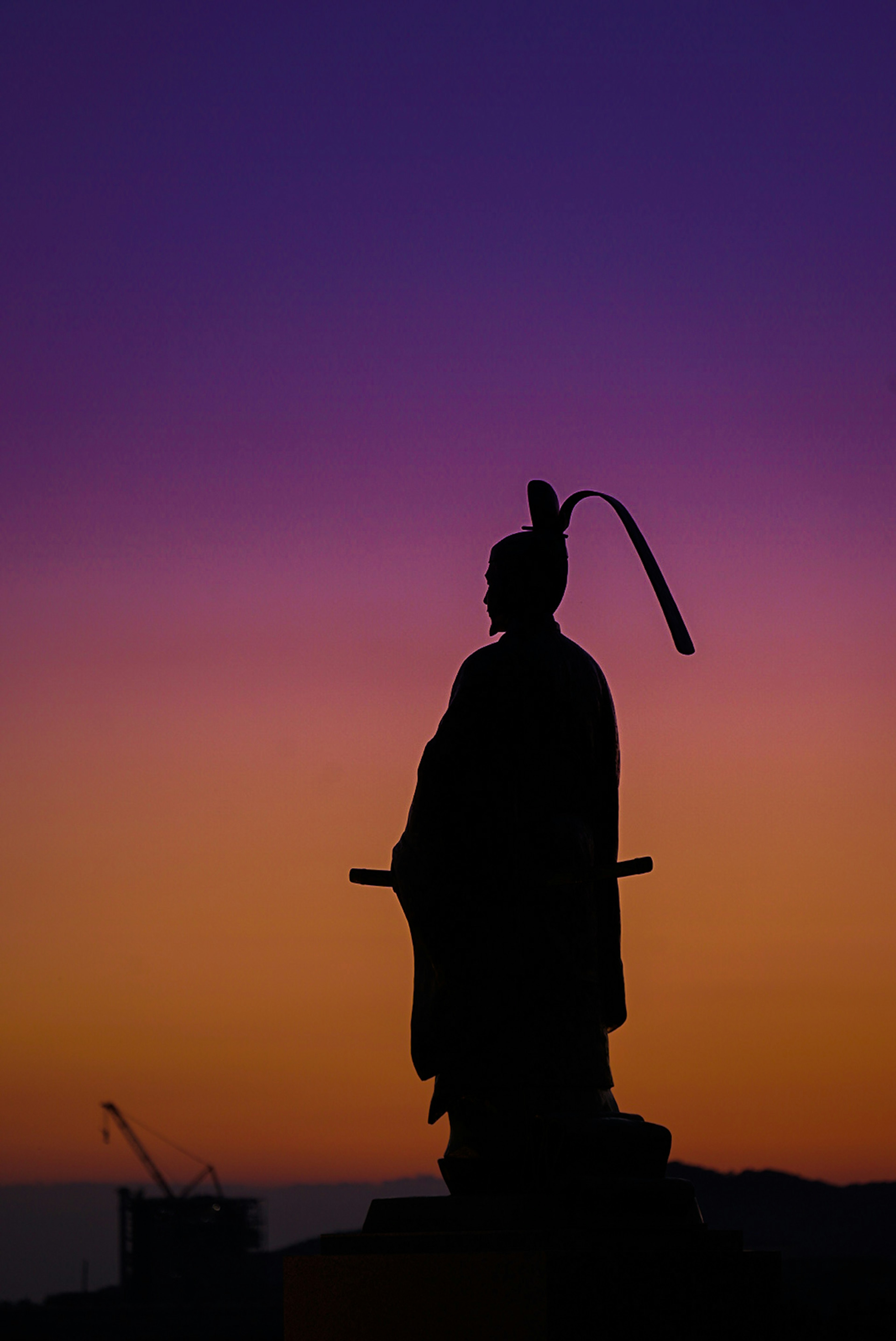 夕焼けの中に立つ武士のシルエット