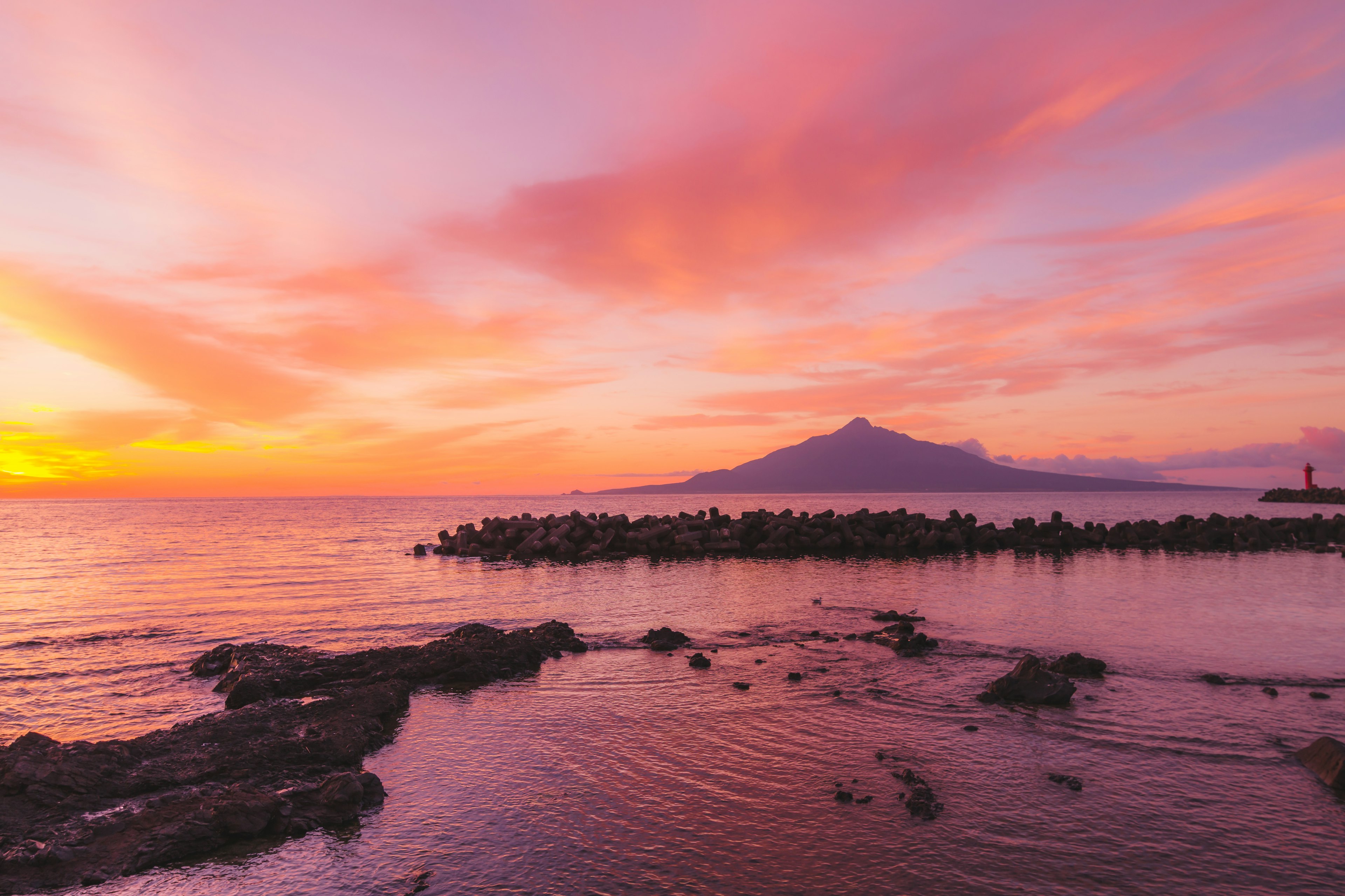 Magnifique paysage de coucher de soleil sur la mer et les montagnes avec un ciel rose et orange