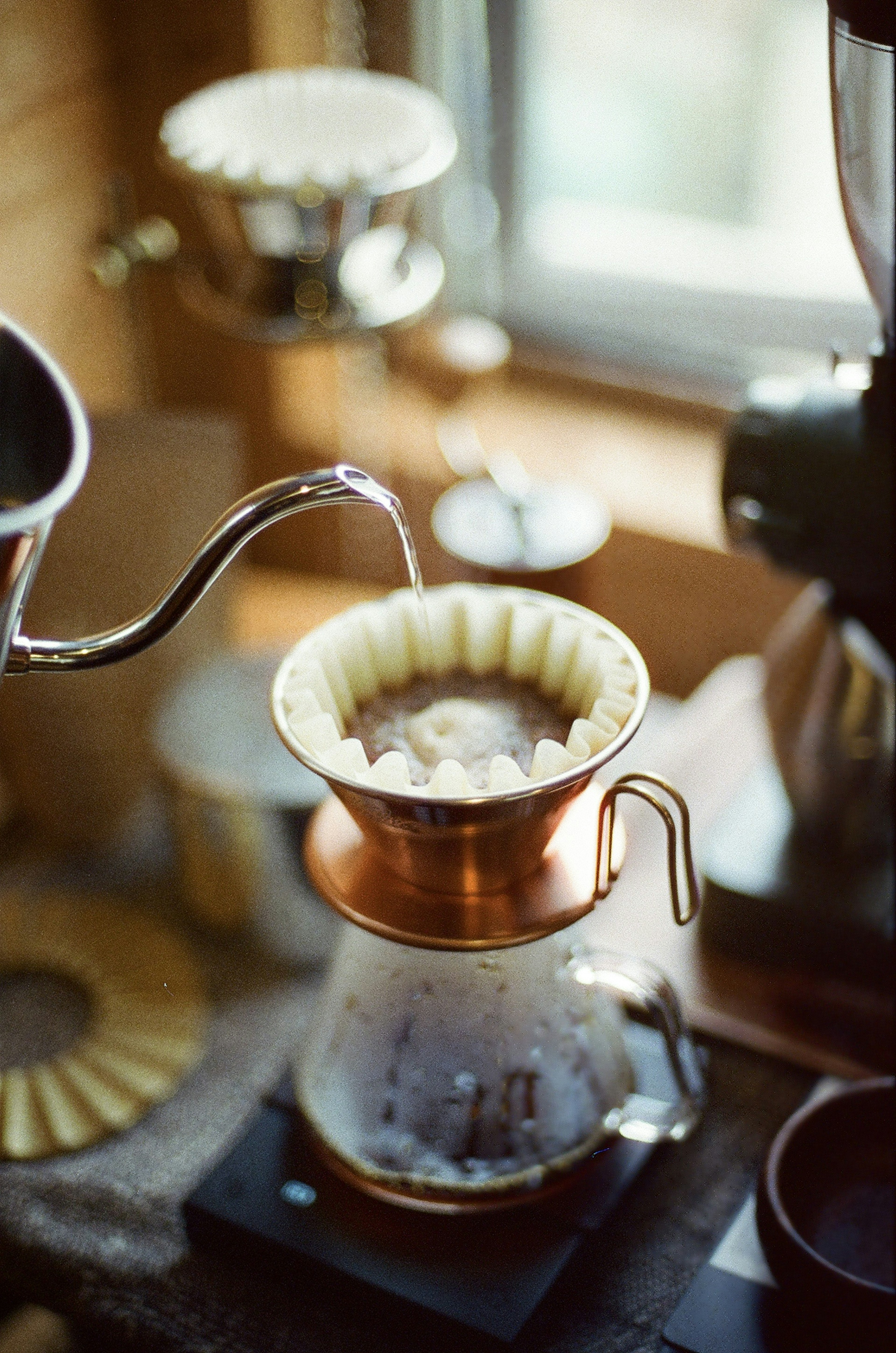 Foto penyaring kopi dengan teko yang menuangkan air