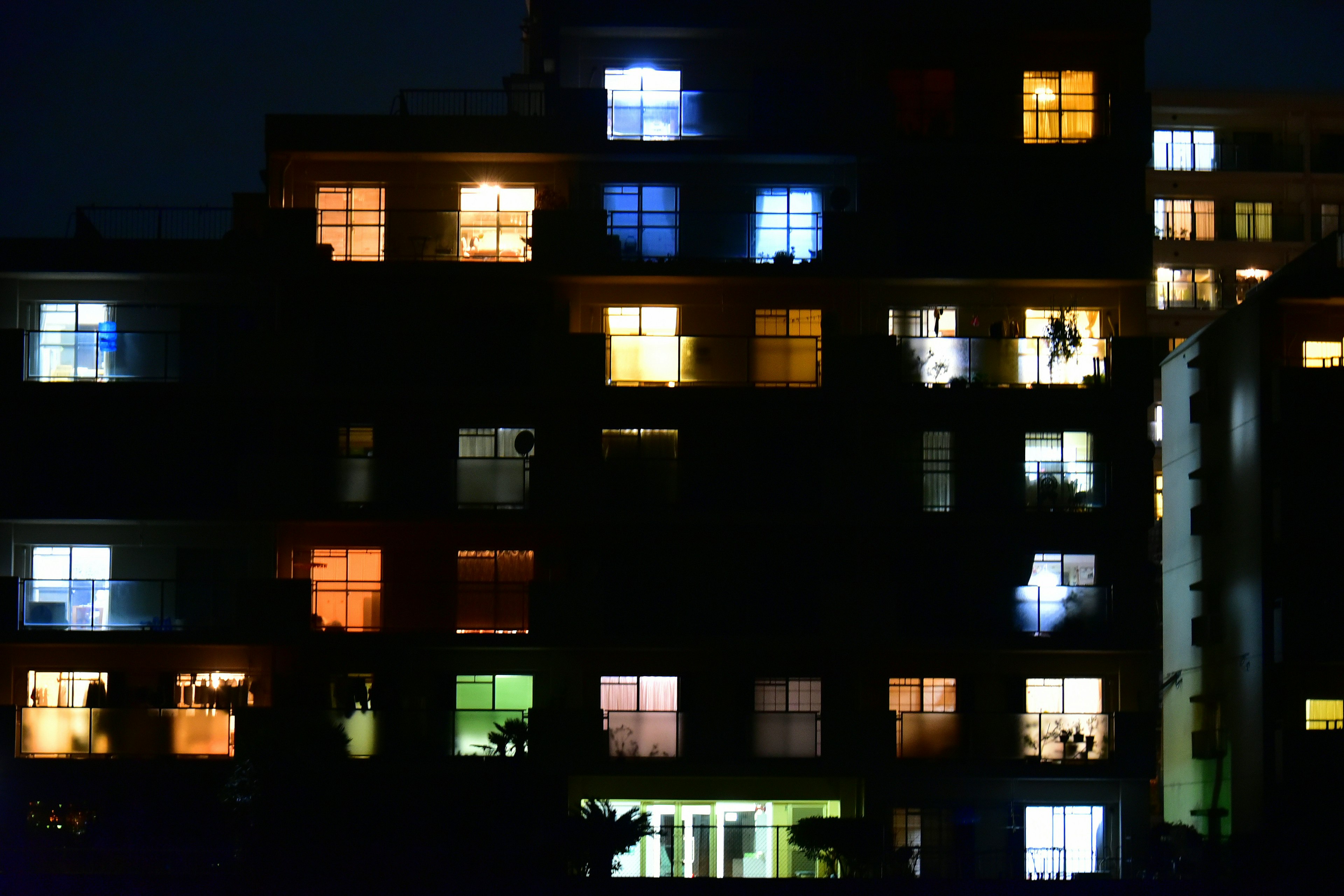 Pemandangan malam gedung apartemen dengan jendela yang menyala