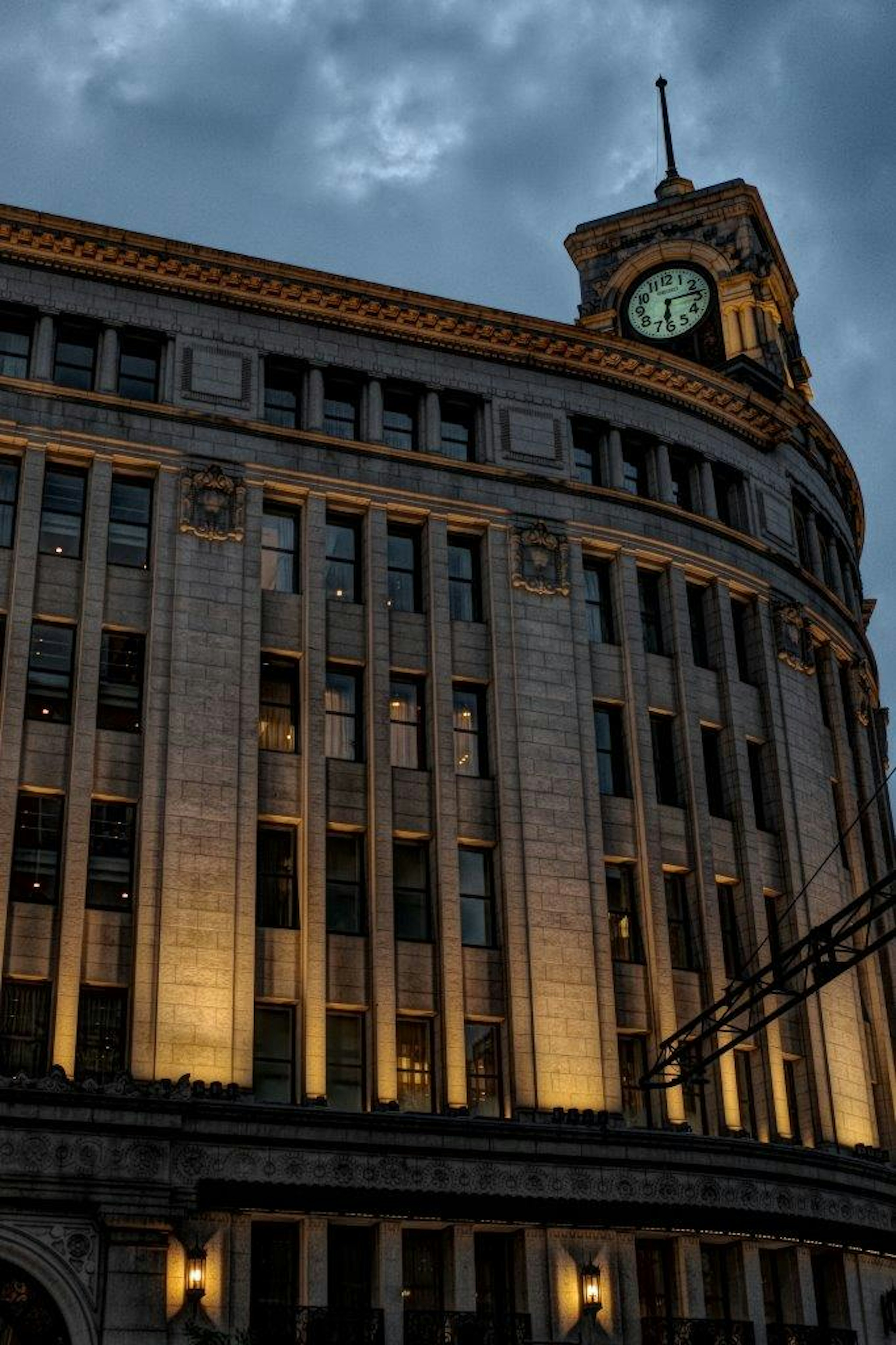 Corner of a beautiful building with a clock tower at dusk