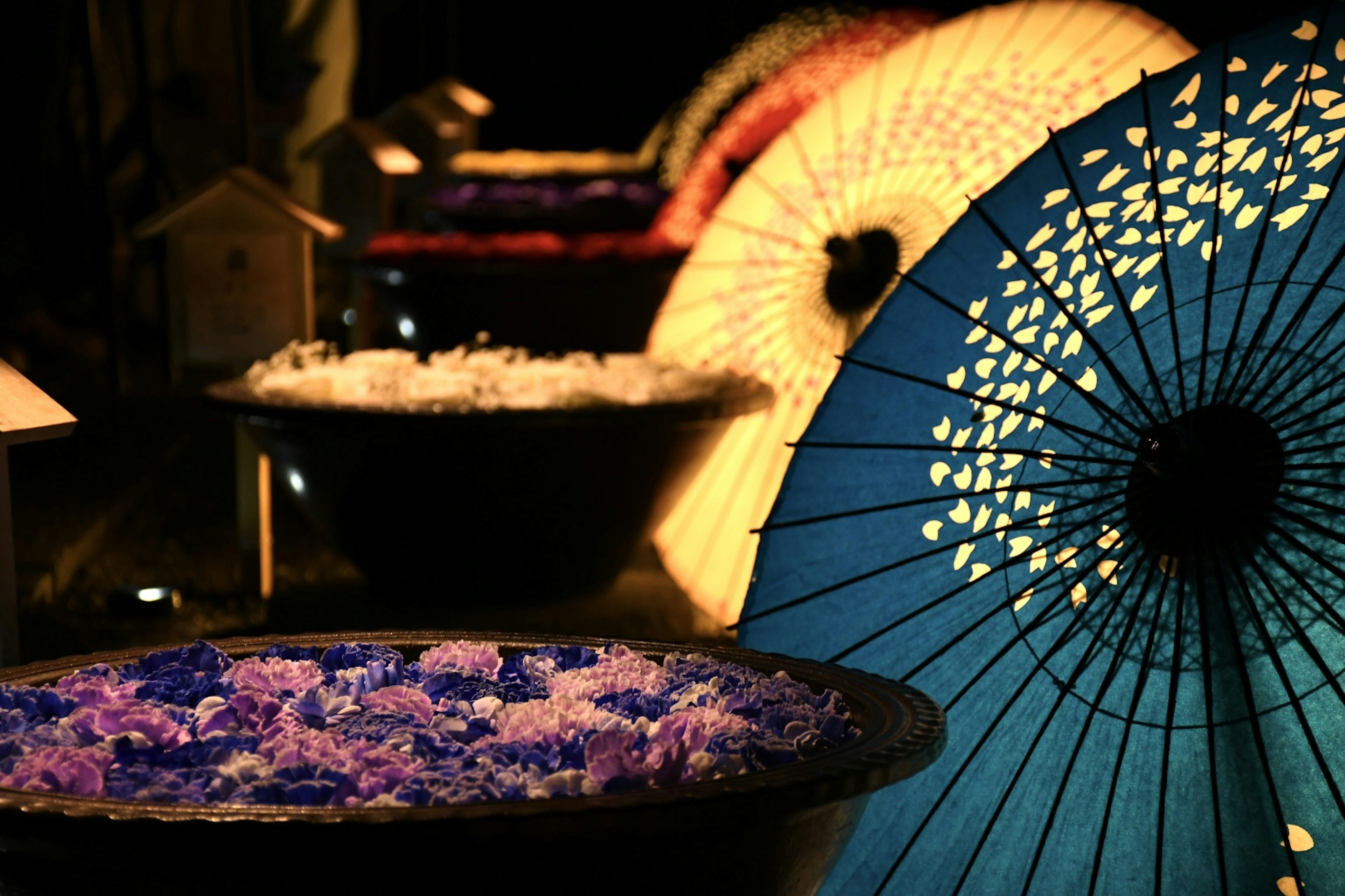 Colorful umbrellas and bowls filled with flower petals create a beautiful scene