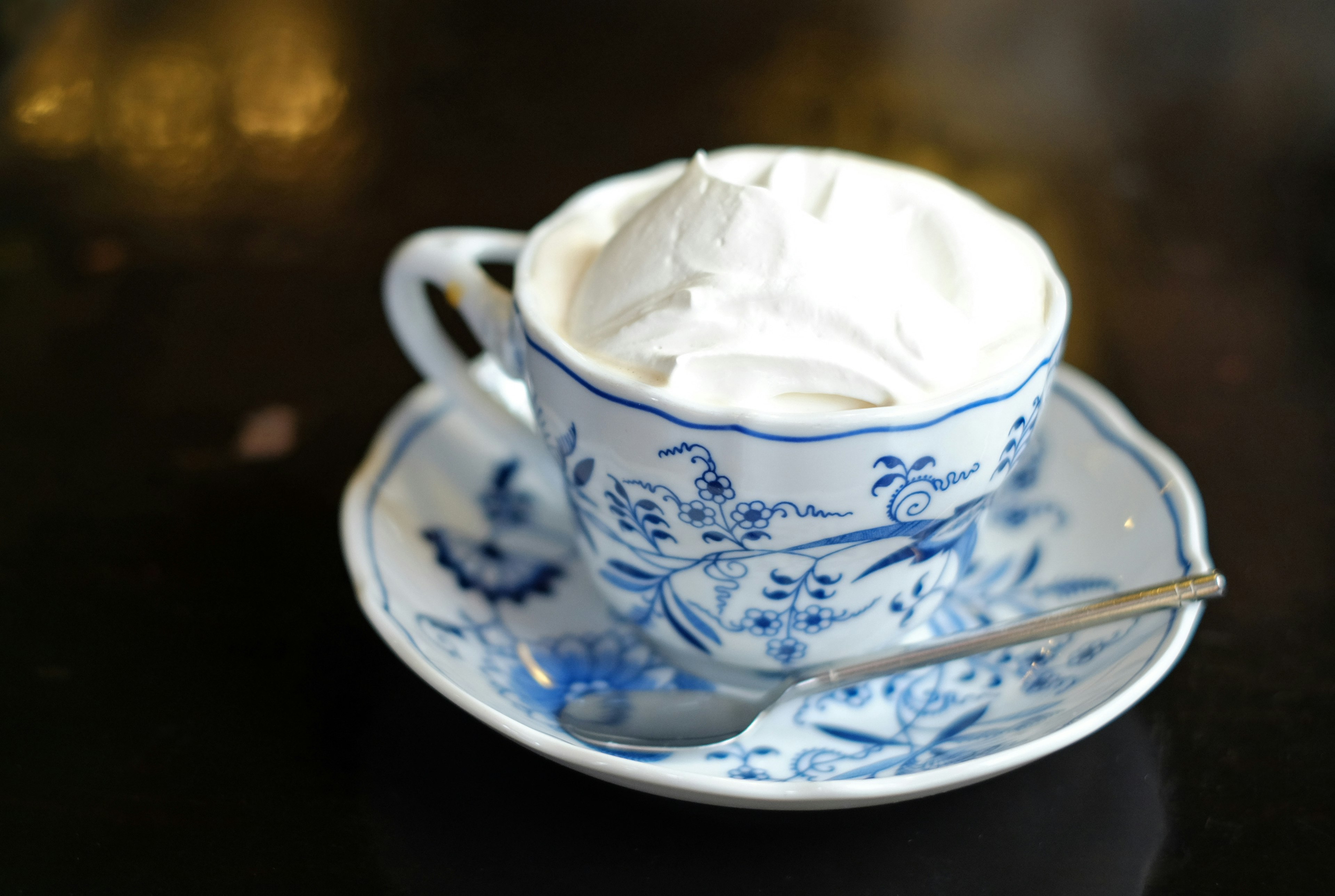 Crema batida servida en una taza con patrón floral azul