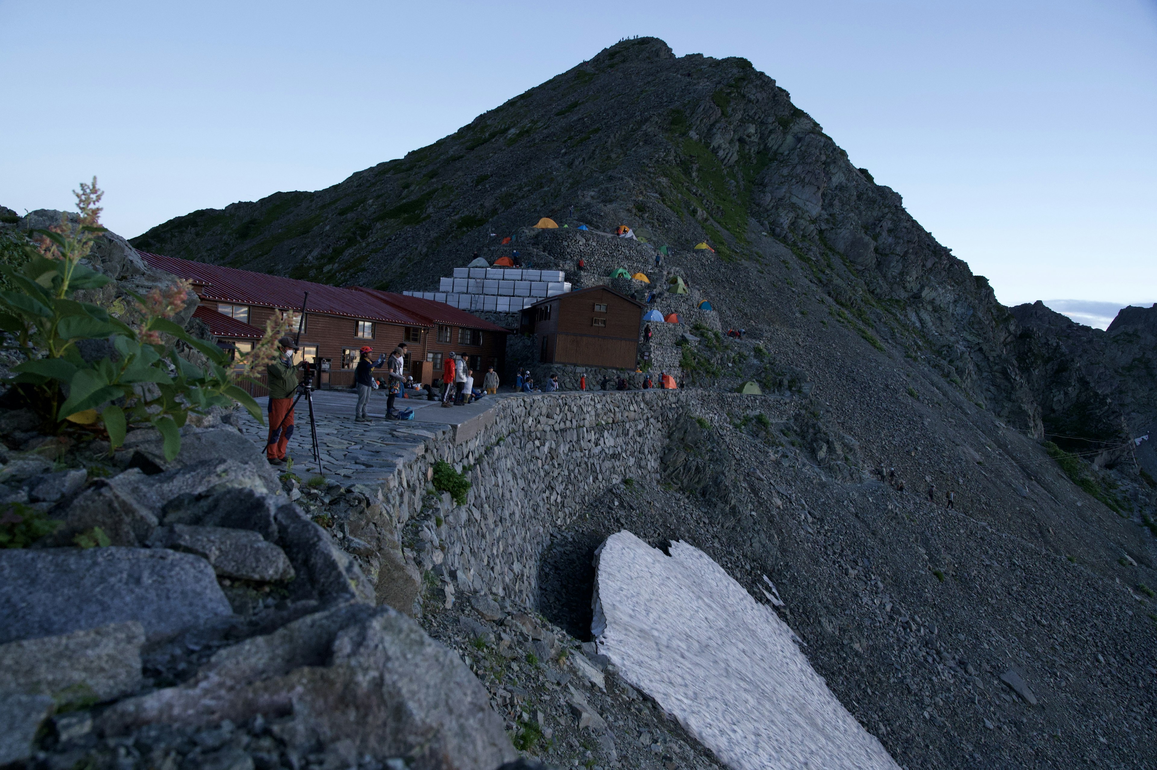 Berg-Hütte mit Wanderern in der Dämmerung