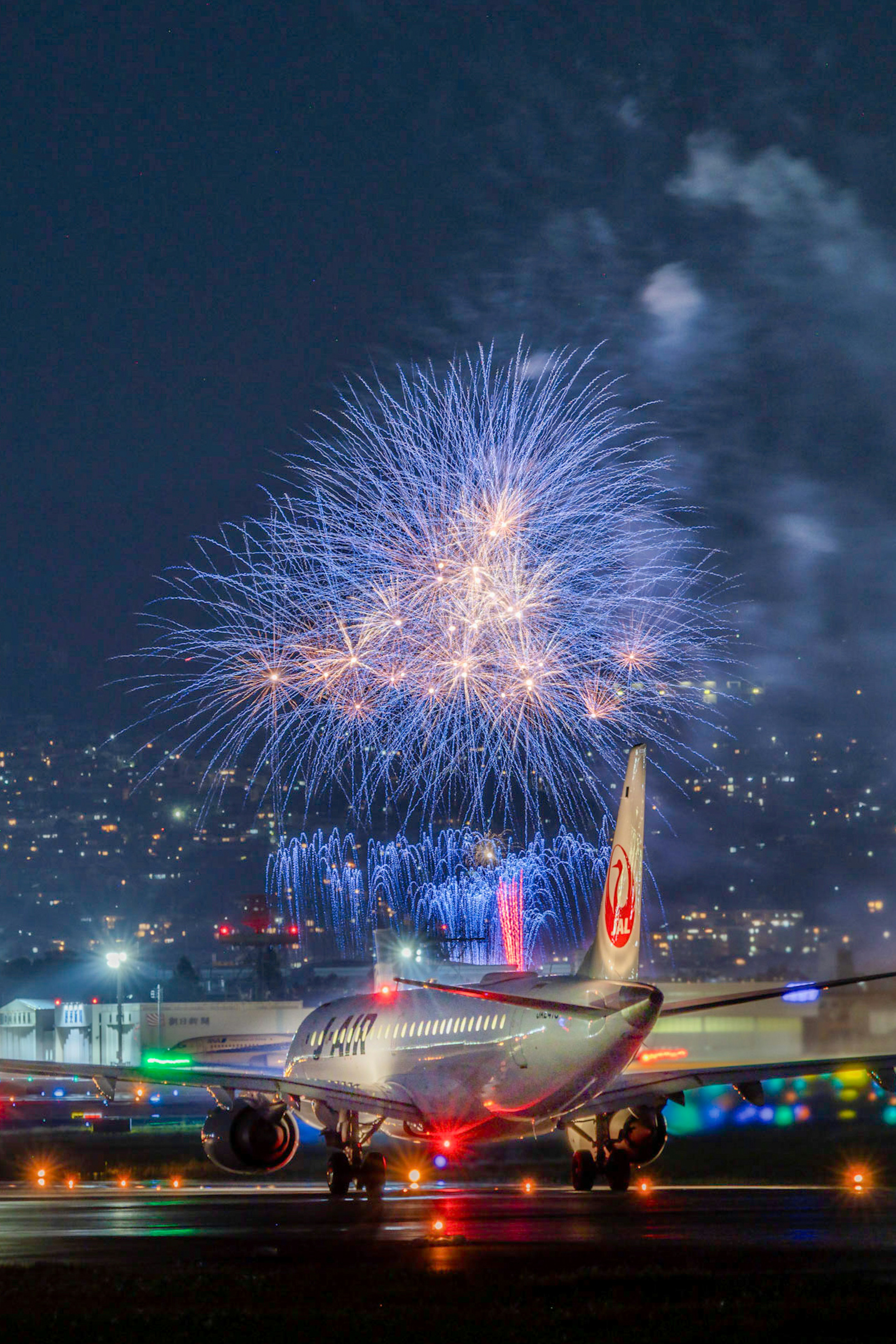 夜空に花火が打ち上げられた空港での飛行機